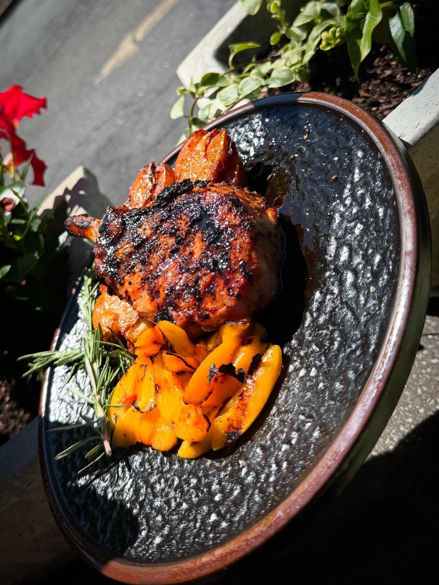 Hot Honey Peach Pork Chop- 12 oz center cut pork chop grilled and glazed with hot honey and grilled peaches, served over smashed potatoes with fresh rosemary