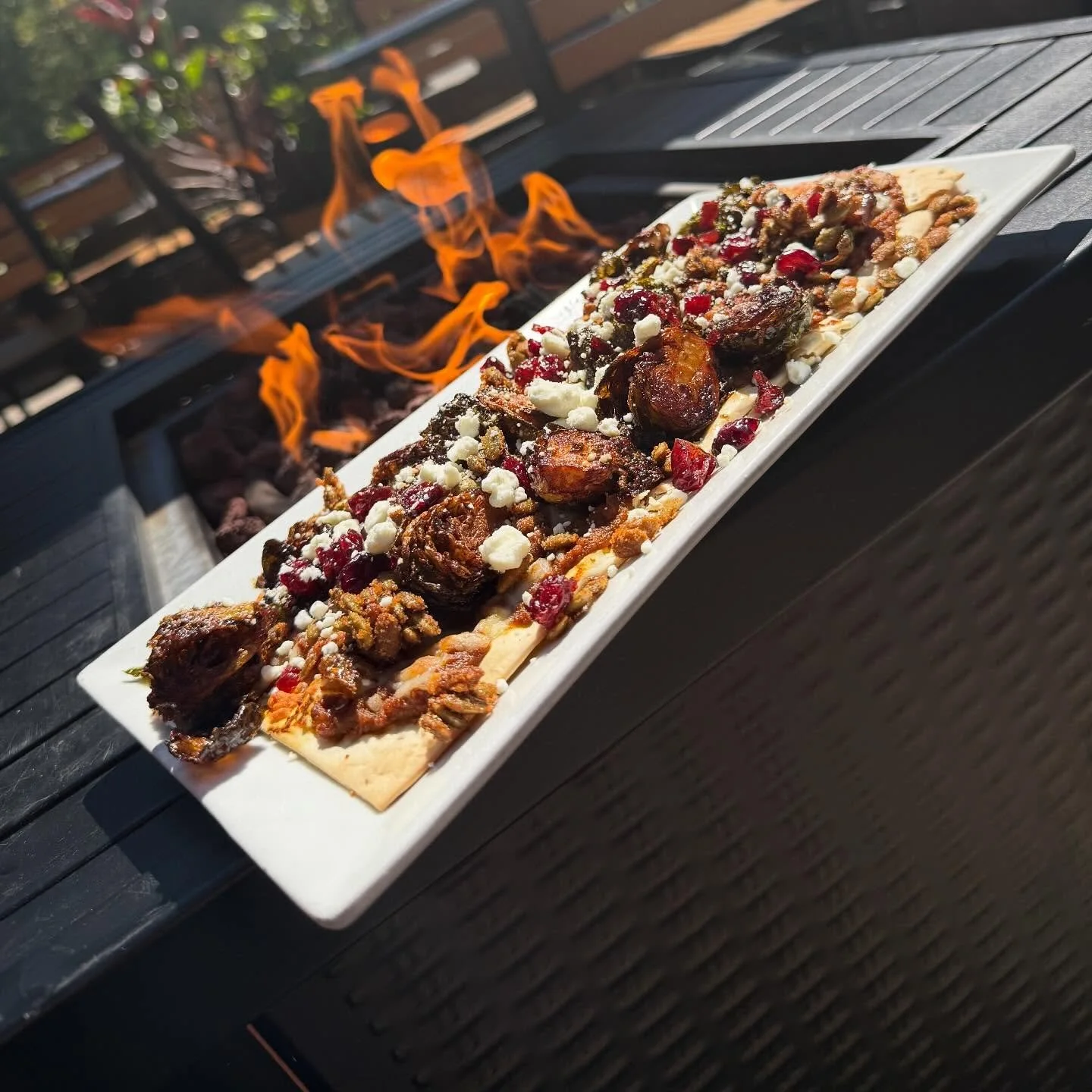 Pilots Bravo Brussels- Crispy thin crust flatbread topped with spiced pumpkin puree, Monterey Jack cheese, maple brussels sprouts, dried cranberries, candied Cajun pumpkin seeds and goat cheese