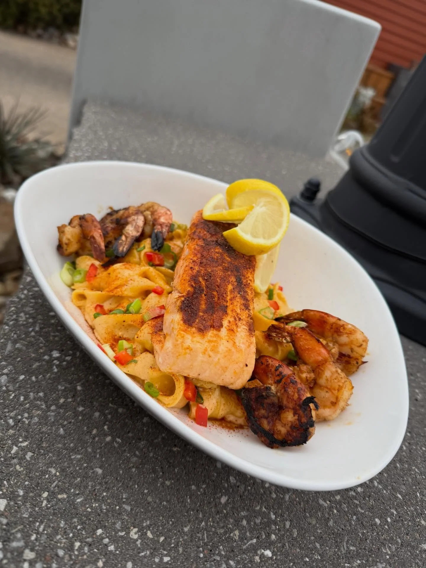 First Class Salmon &amp; Shrimp- Cajun seared salmon and jumbo shrimp over pappardelle pasta tossed with a lemon-garlic parmesan cream sauce, finished with Cajun spice, peppers and green onions