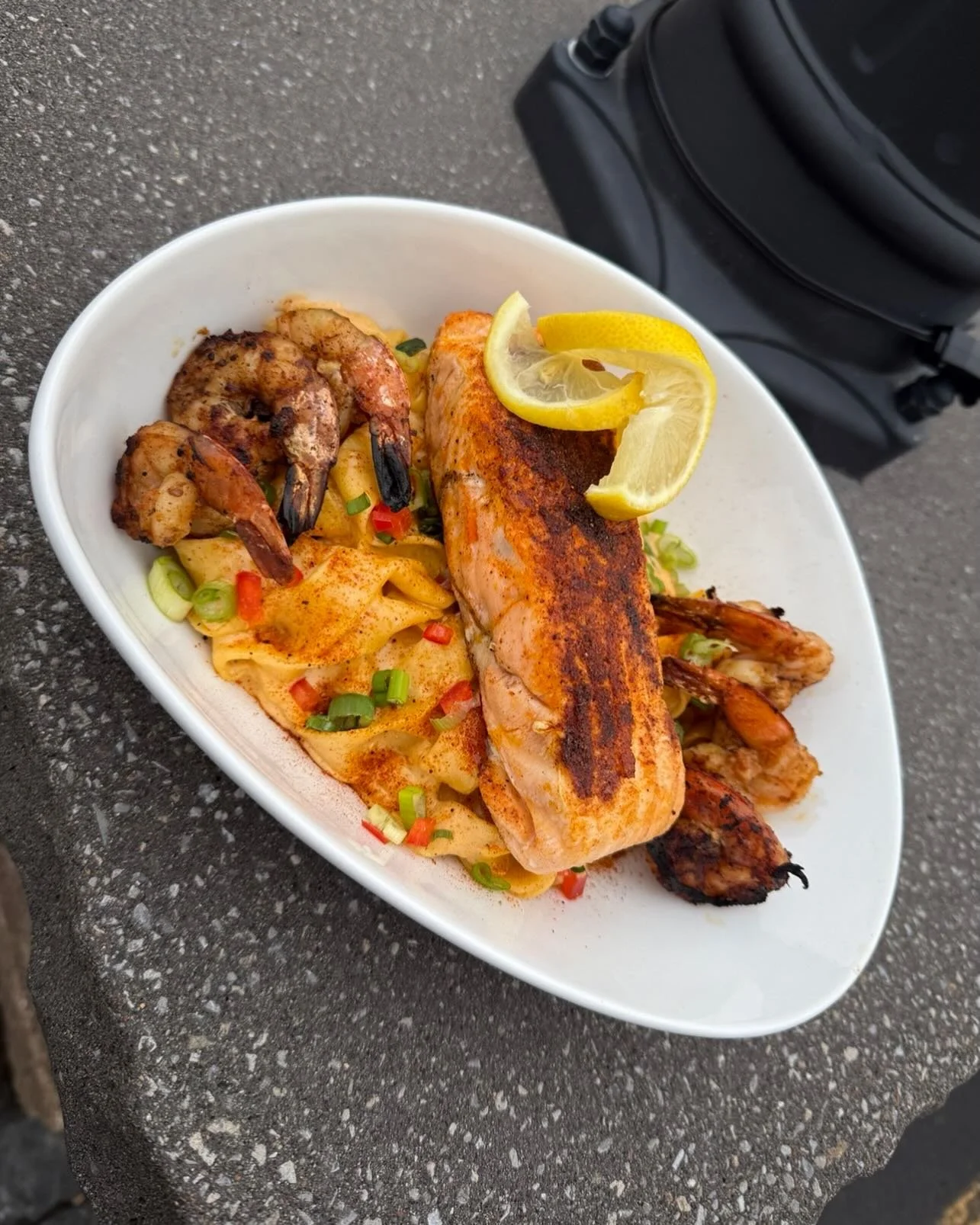 First Class Salmon &amp; Shrimp- Cajun seared salmon and jumbo shrimp over pappardelle pasta tossed with a lemon-garlic parmesan cream sauce, finished with Cajun spice, peppers and green onions