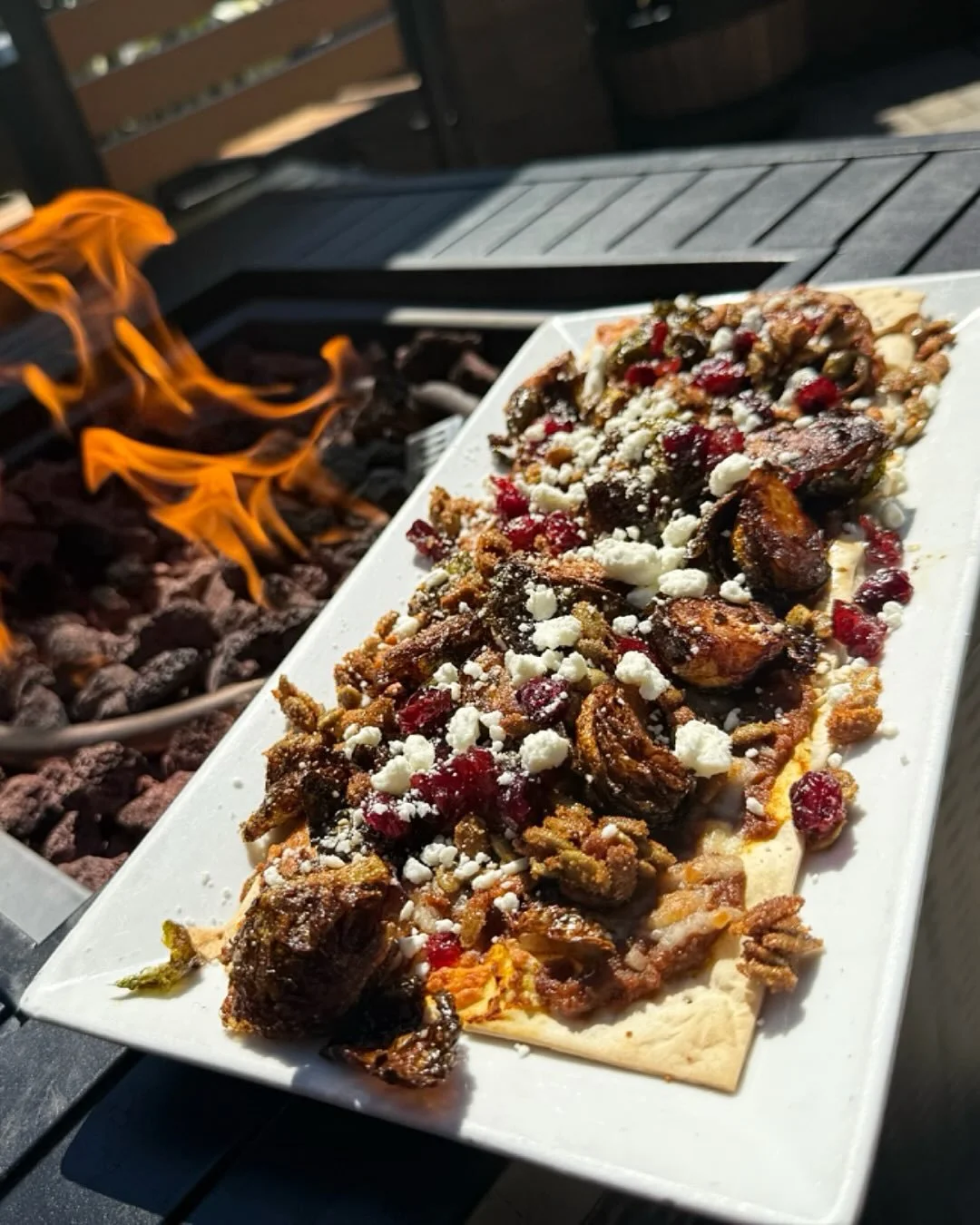 Pilots Bravo Brussels- Crispy thin crust flatbread topped with spiced pumpkin puree, Monterey Jack cheese, maple brussels sprouts, dried cranberries, candied Cajun pumpkin seeds and goat cheese