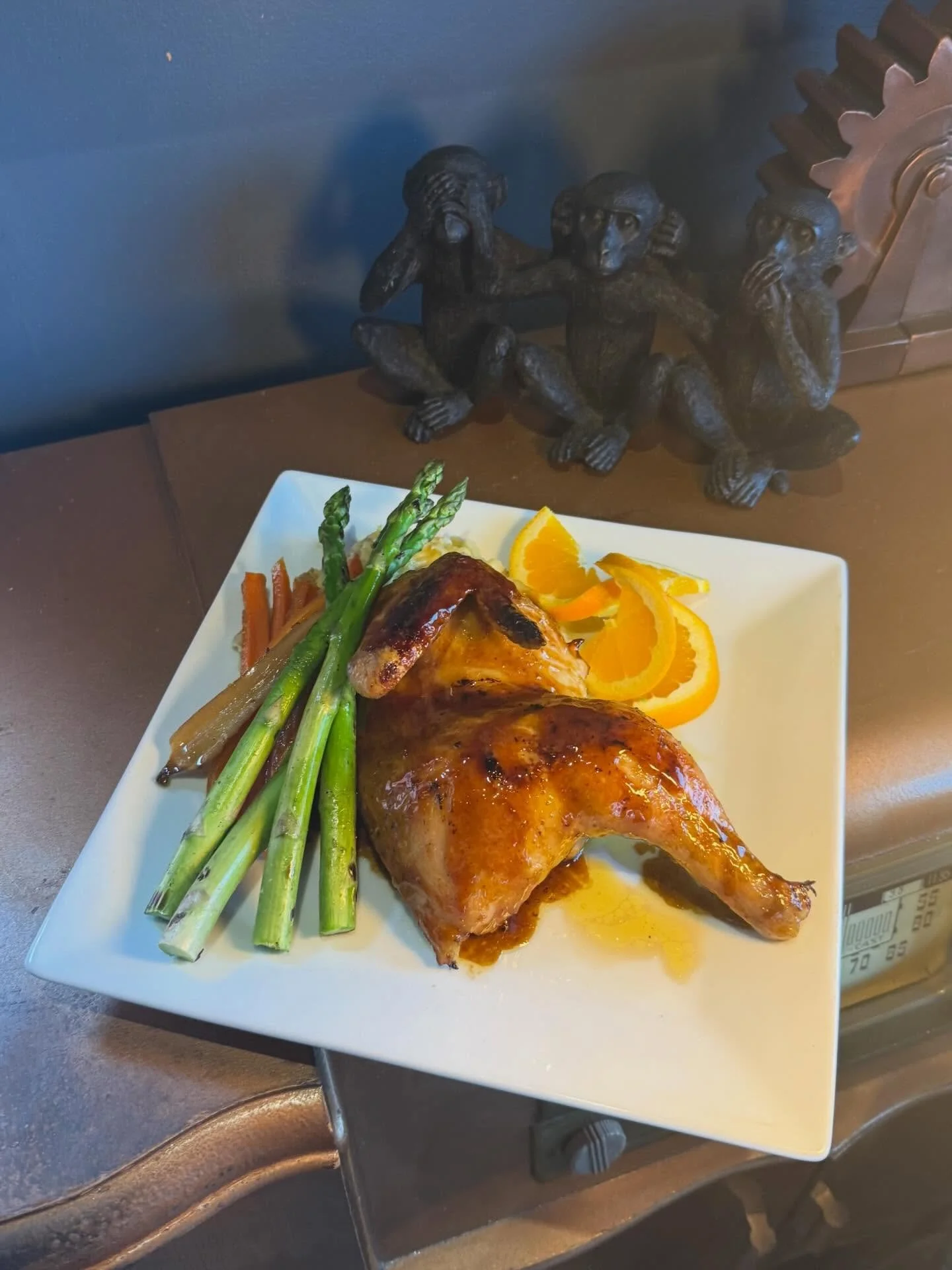 Crosscheck Chicken - Cherry bourbon crosscheck-glazed half chicken roasted to perfection with subtle citrus lift, plated alongside maple-roasted heirloom carrots, charred asparagus, and buttery Yukon Gold potato pur&eacute;e