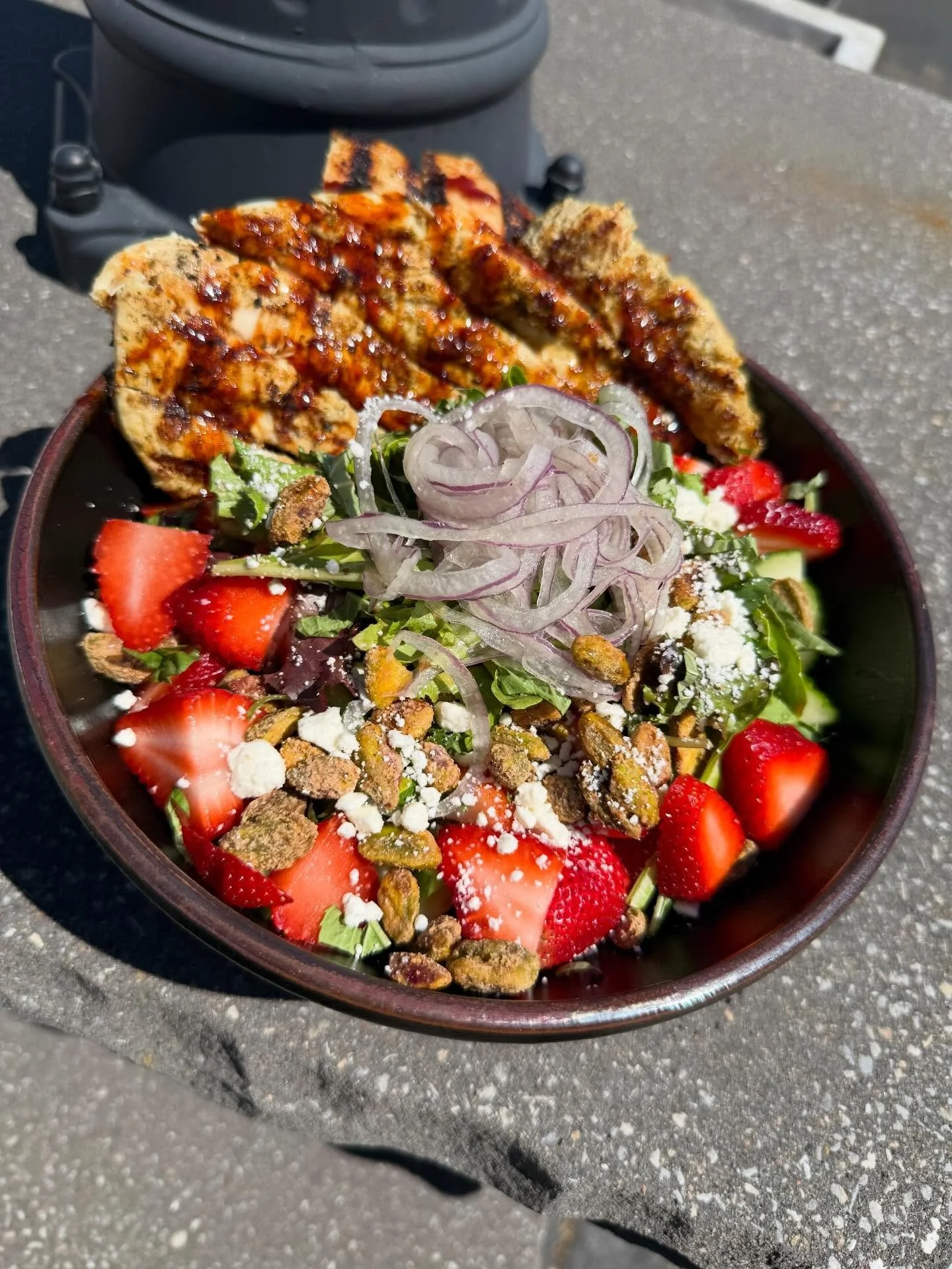 Sweet Heat Strawberry- Spinach tossed with honey balsamic and topped with sliced strawberries, shaved cucumbers, goat cheese, red onion, cajun candied pistachios, and fresh basil. Finished with marinated grilled chicken