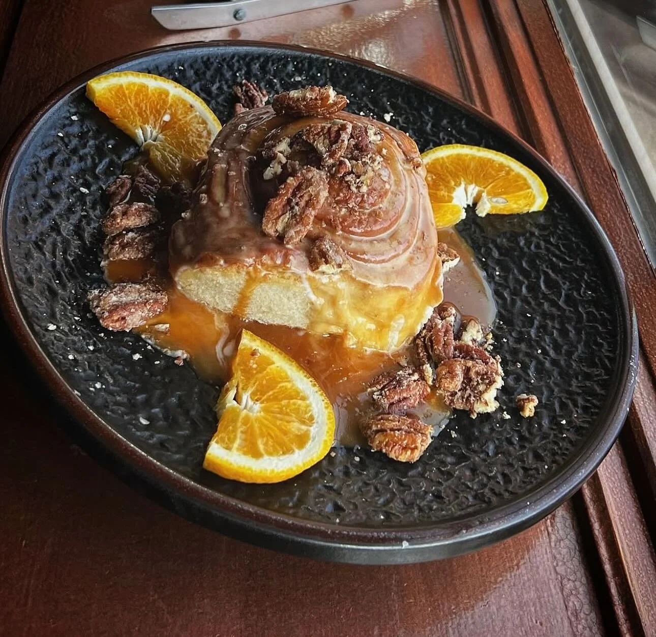 Monkey Sticky Bun- Jumbo cinnamon bun topped with candied pecans, house-made Grand Marnier sauce with touches of caramel and orange zest