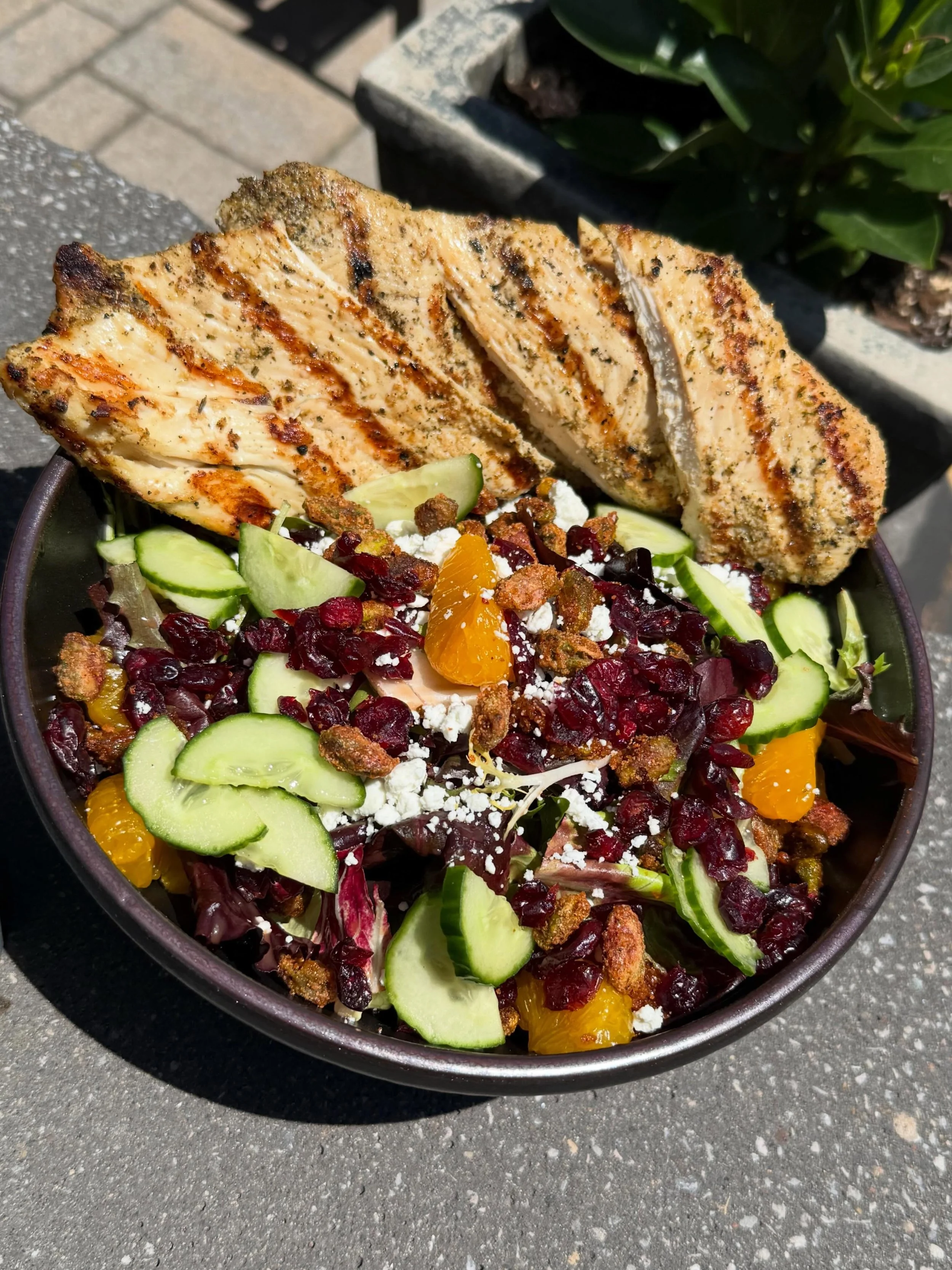 Bravo Blood Orange Salad- Mixed greens tossed with a blood orange vinaigrette, topped with mandarin oranges, goat cheese, cajun pistachios, cucumber, and dried cranberries, finished marinated grilled chicken