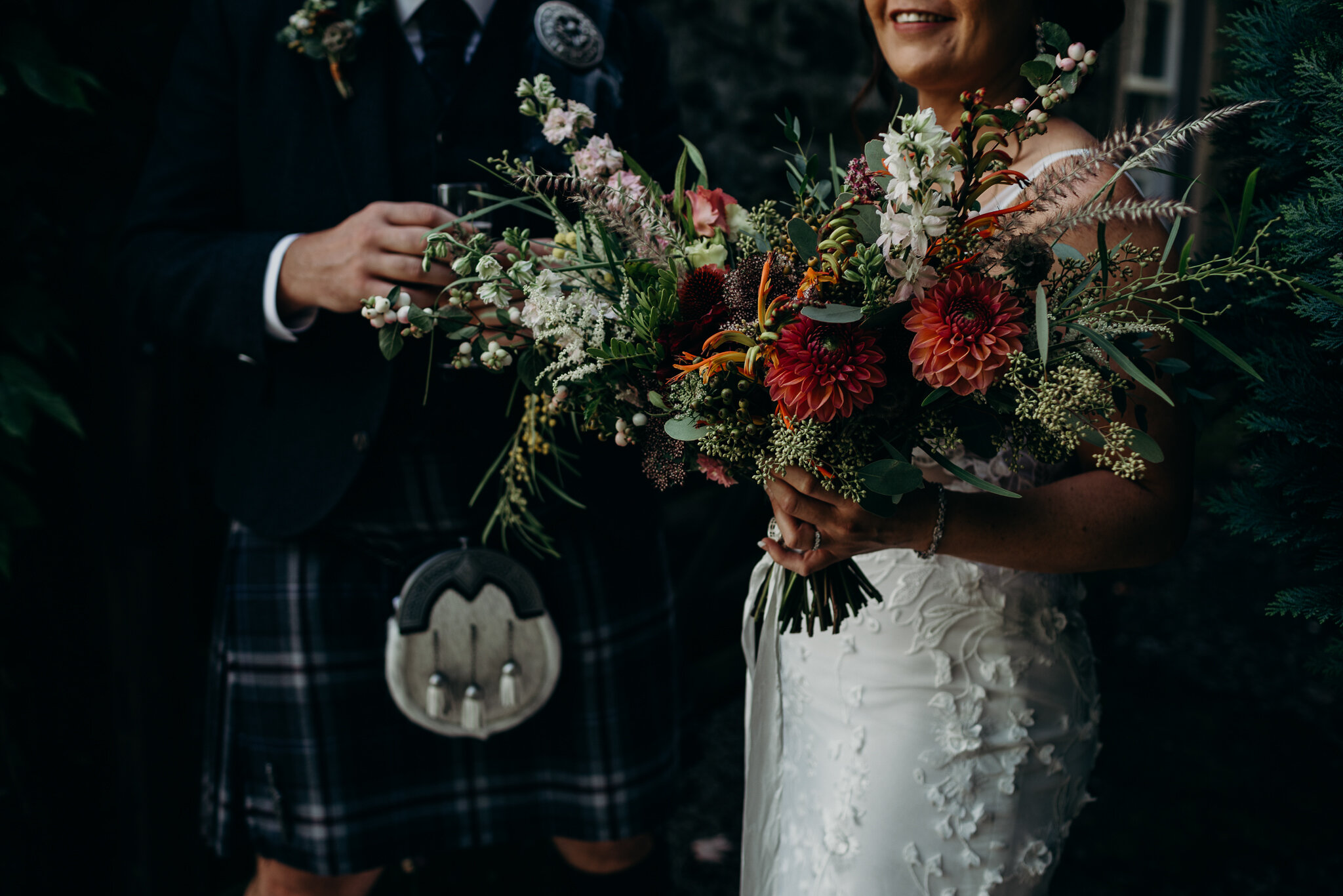 bride holding bouquet in autumnal colours by sparrow &amp; rose flowers outdoors at dalduff farm photographed by wedding photographer ayrshire scotland