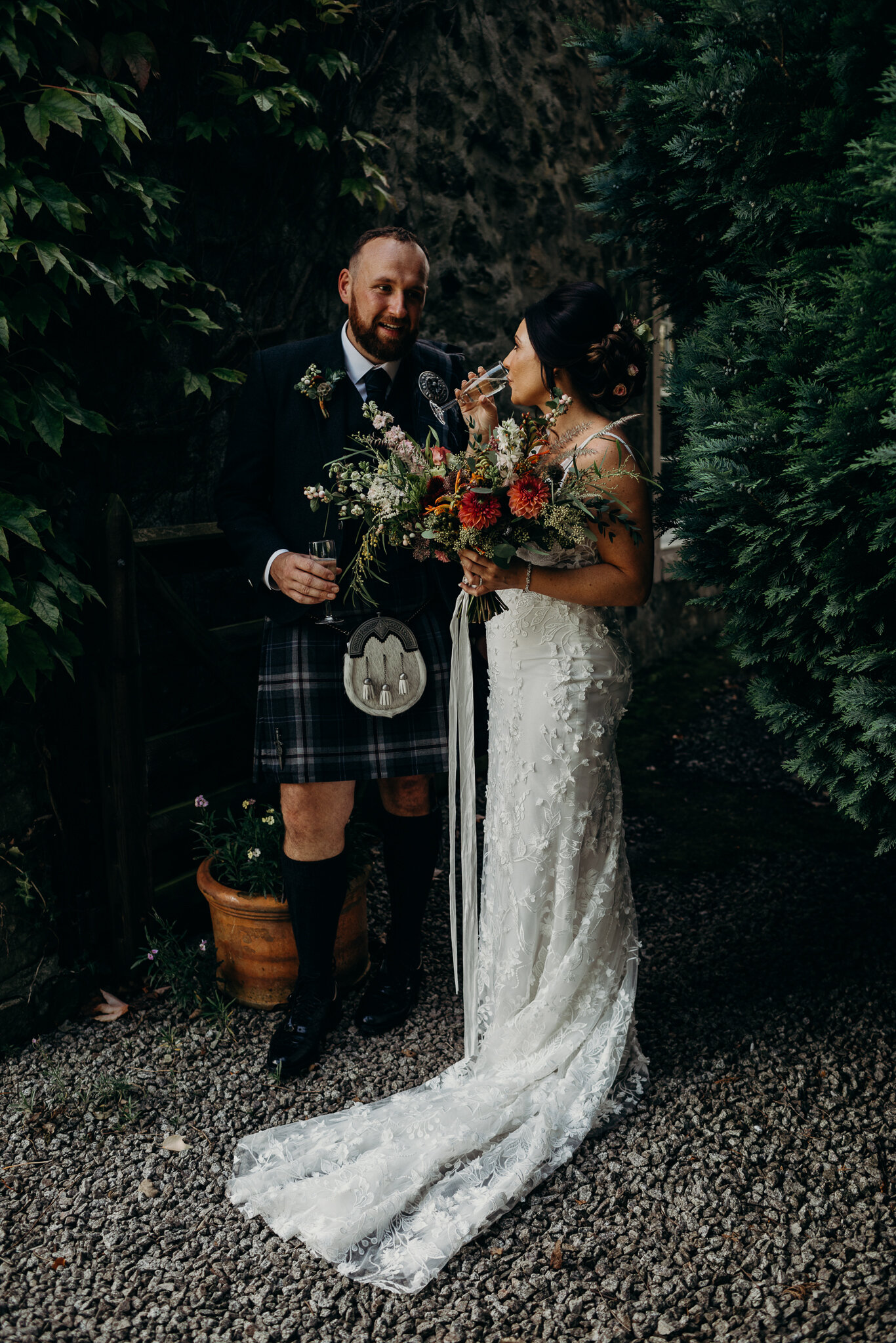 groom standing with bride wearing unbridaled dress outdoors at dalduff farm barn wedding photographed by wedding photographer ayrshire