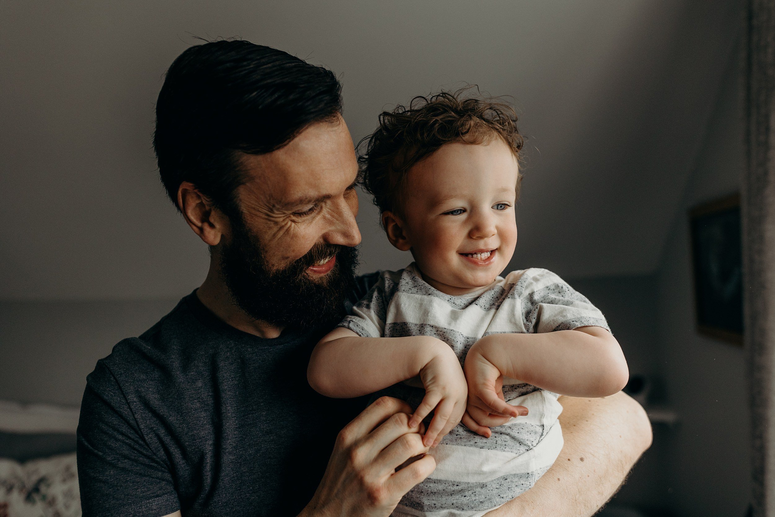 dad smiles and hugs toddler during photo session baby photography glasgow