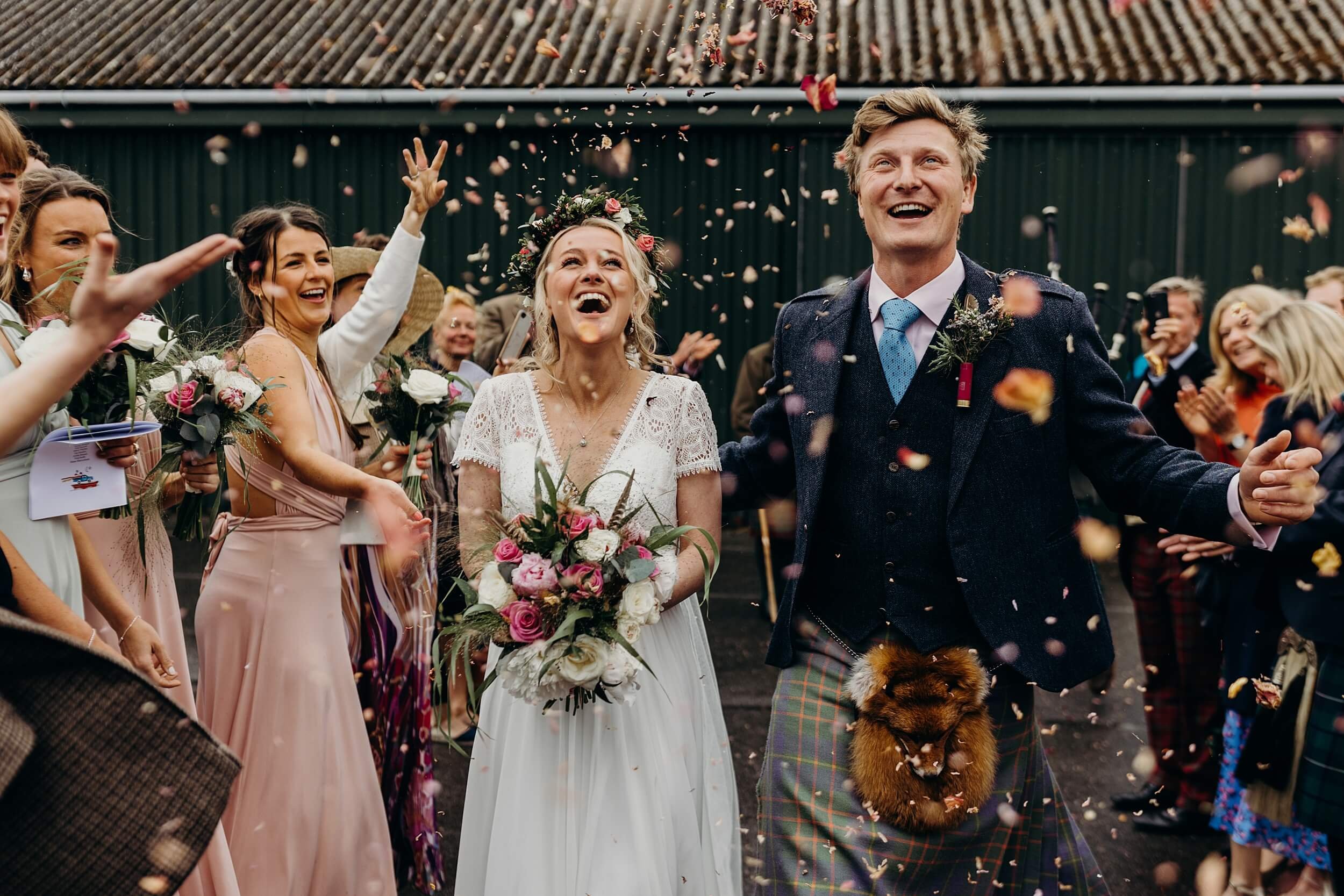 bride and groom are showered in confetti while smiling laughing relaxed and natural wedding photography glasgow scotland