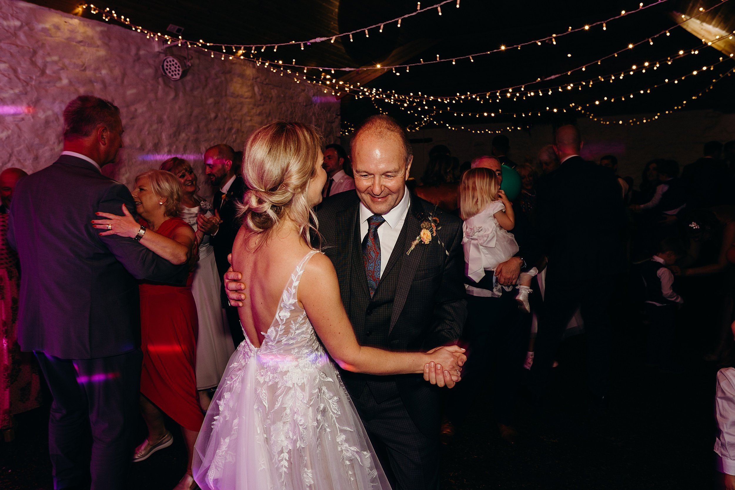 bride dancing with father at farm wedding venue under fairy lights at quirky wedding venue scotland
