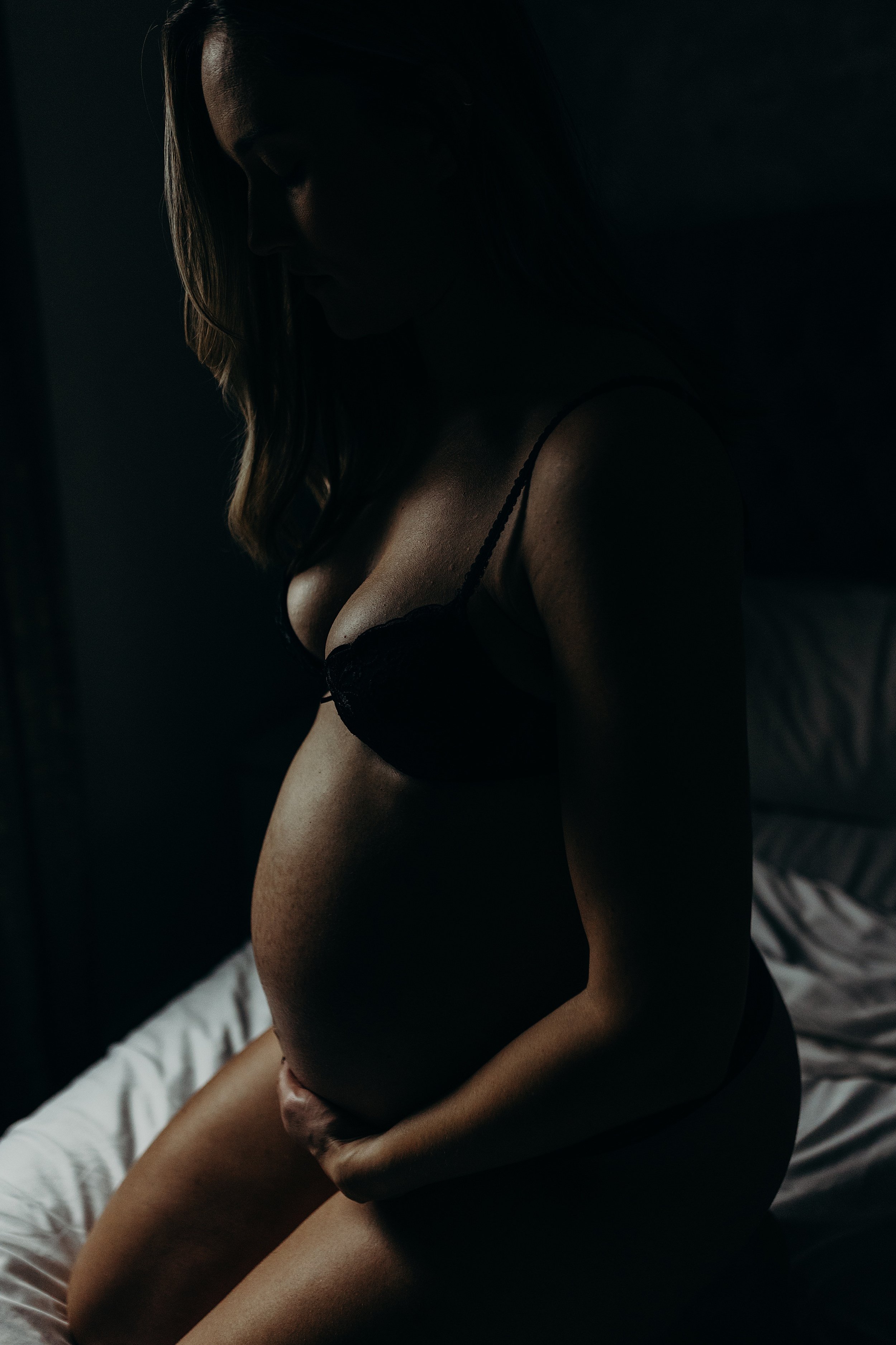 moody photo session showing mum to be holding baby bump during twins maternity photo shoot in Glasgow Scotland