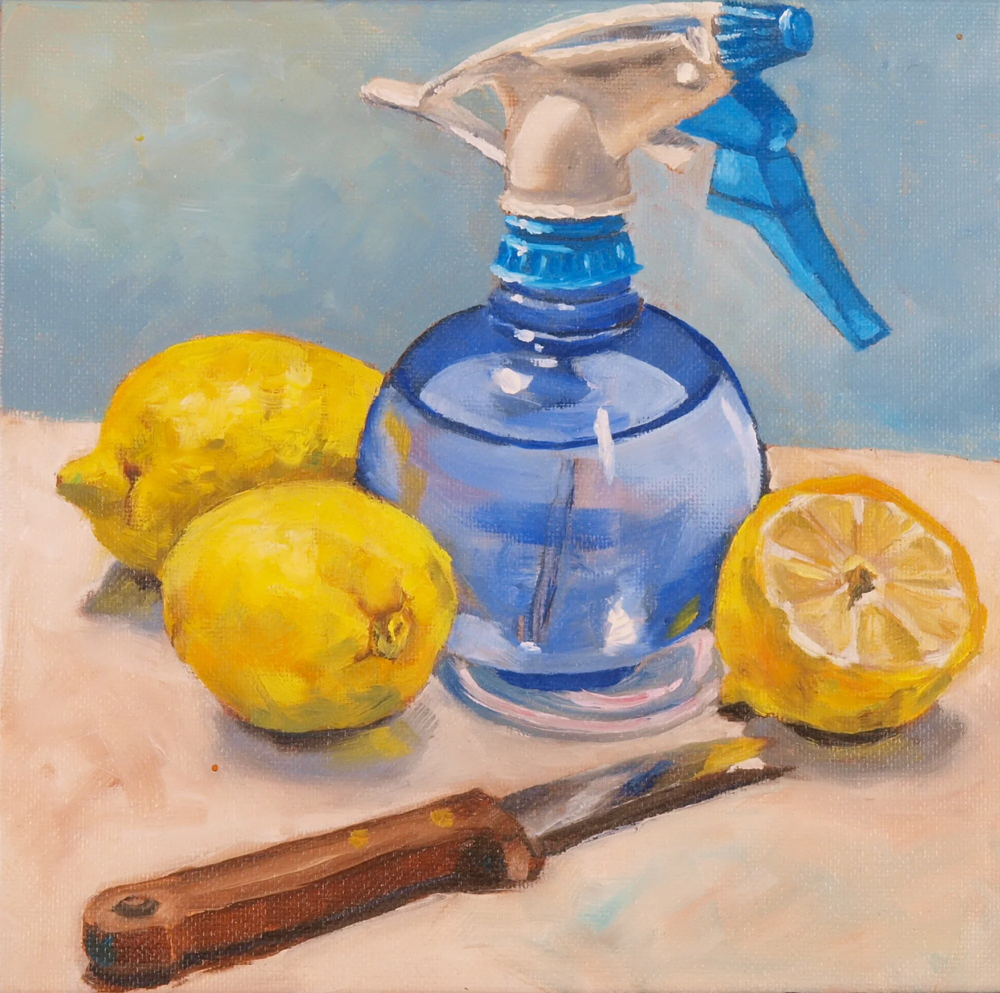 Blaue Sprühflasche mit Zitronen