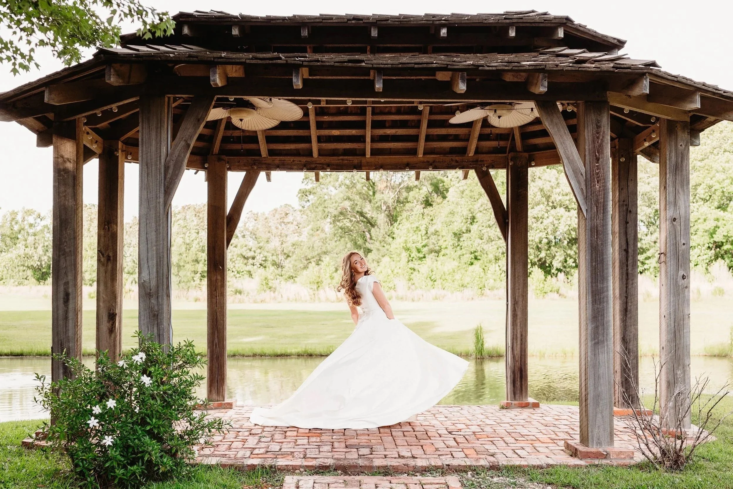 Bride swings dress under large wood gazebo at The Catlett Farm
