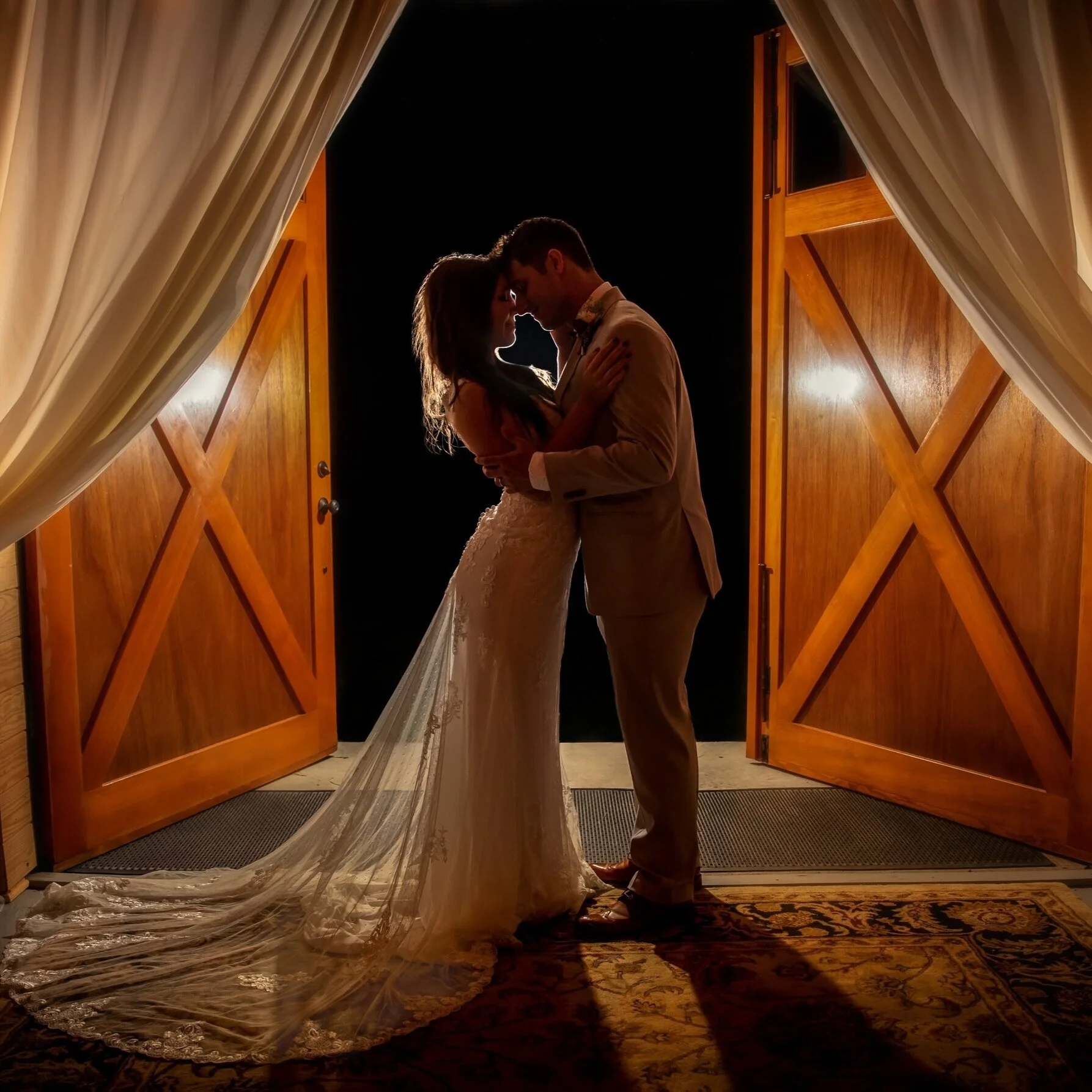 Night photo of wedding couple in front of large Full-X doors