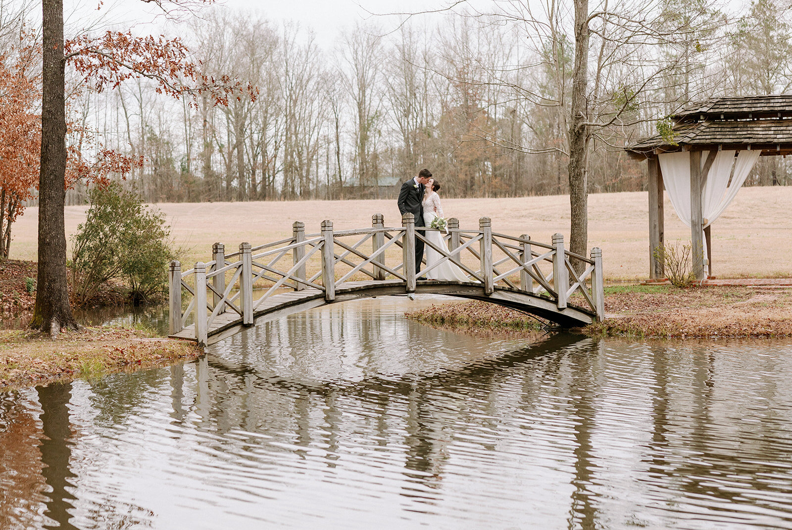 Winter-Bridal-Couple-On-Footbridge-Over-Pond.jpg