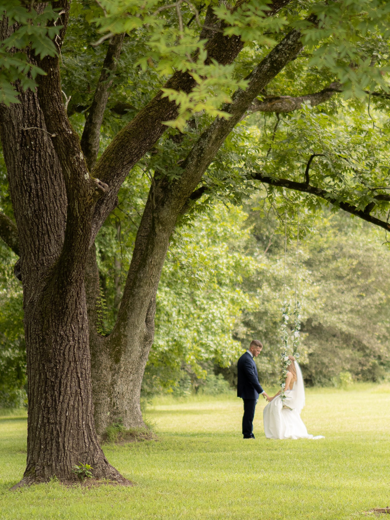 Bridal-Couple-Tree-Swing-In-The-Distance.jpeg
