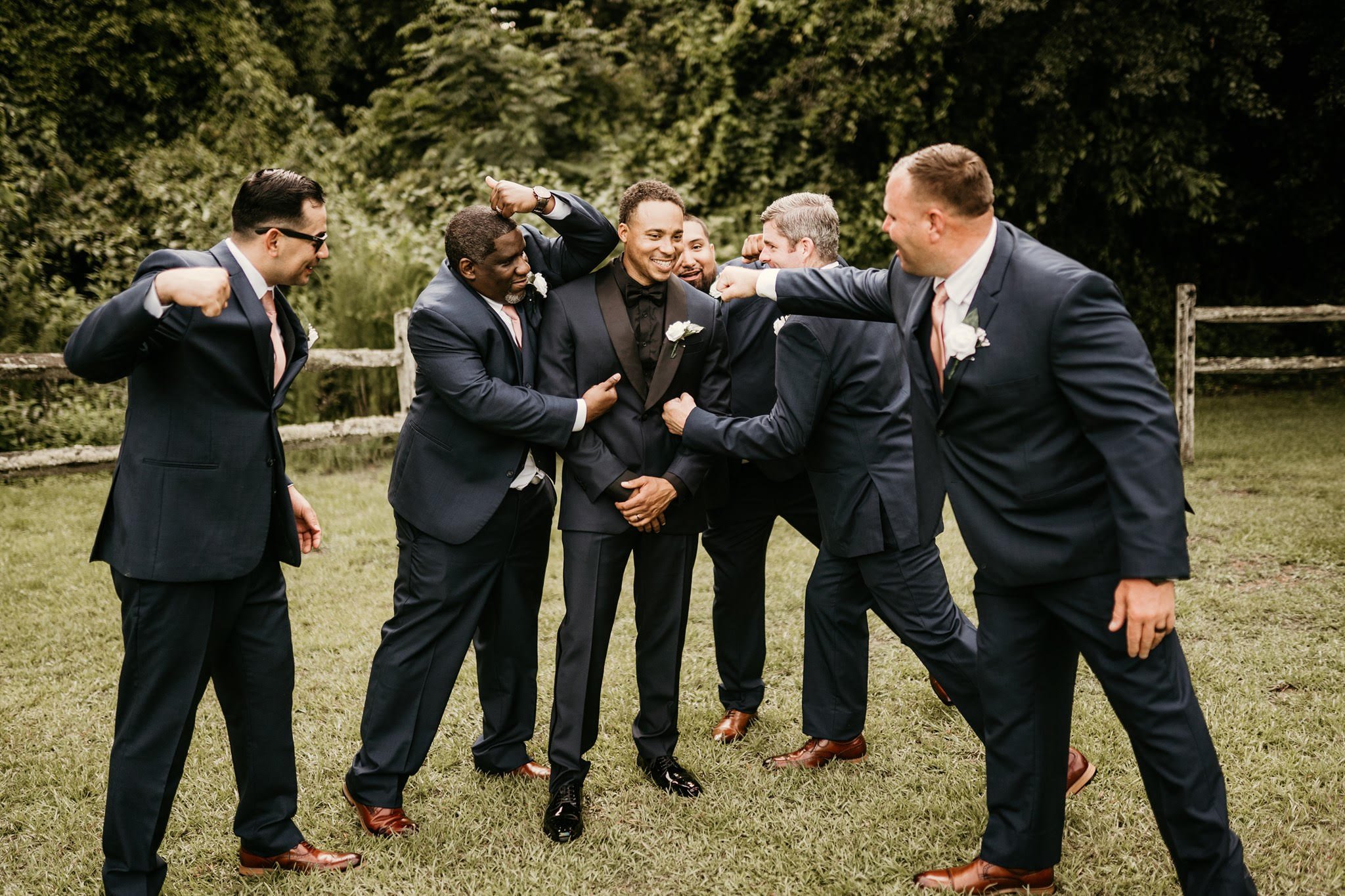 Dark-Suited-Groomsmen-Punch-Smiling-Groom.jpg