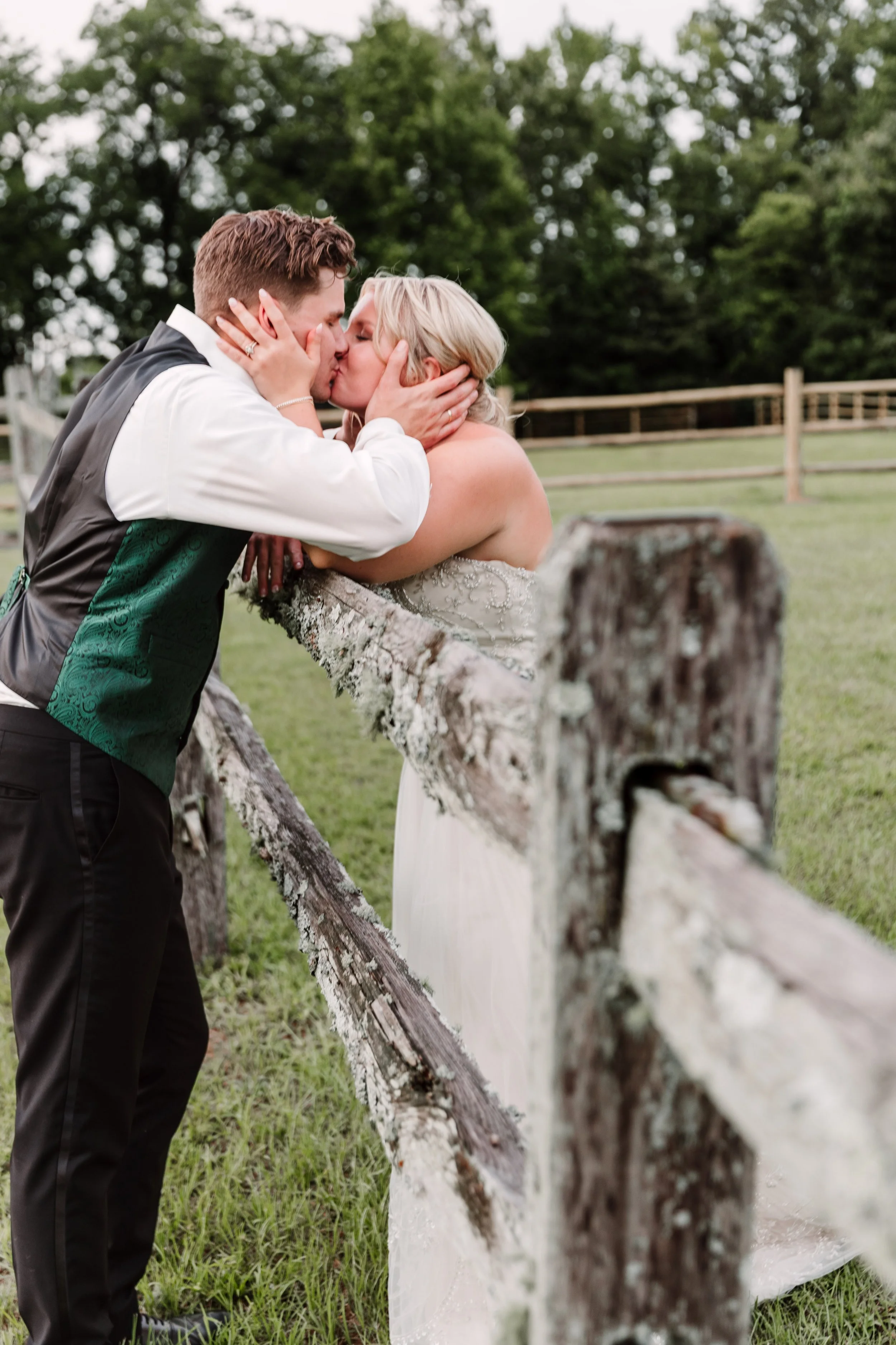 Bridal-Couple-Kissing-Across-Moss-Covered-Fence-.jpg