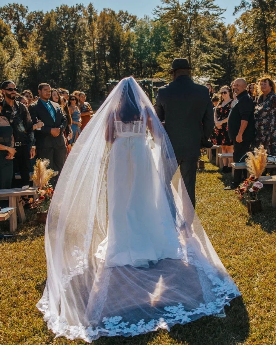 The Catlett Farm outdoor ceremony with bride walking aisle with billowing cathedral veil