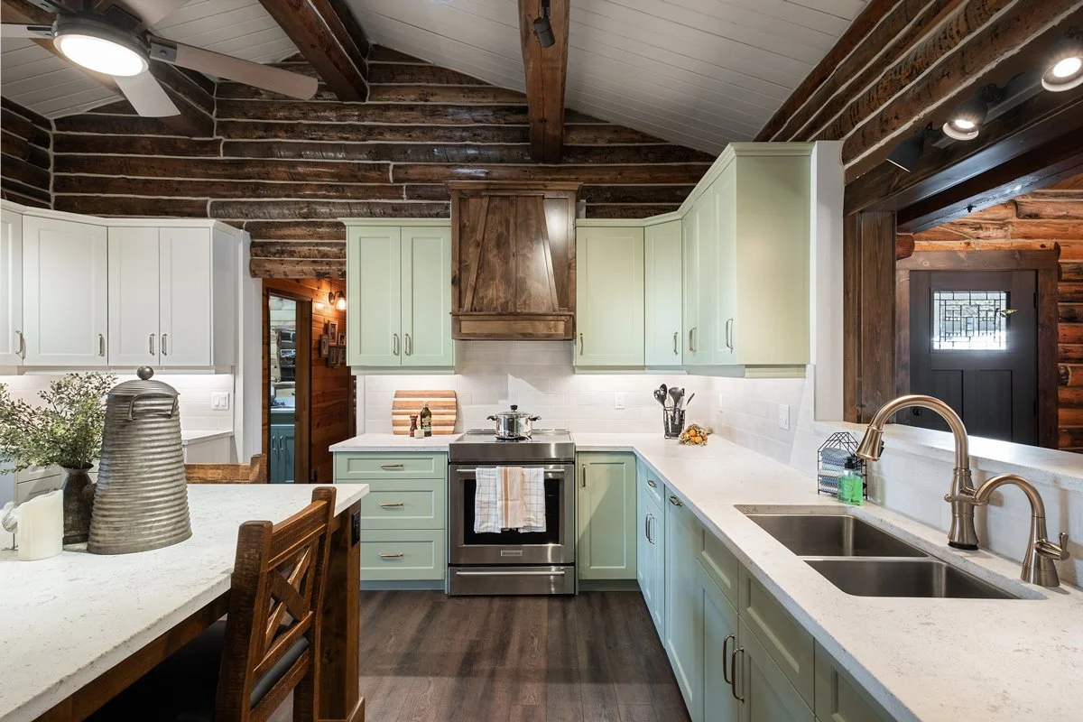 A modern kitchen with white cabinets, a stainless steel oven, a double sink, and wooden accents.