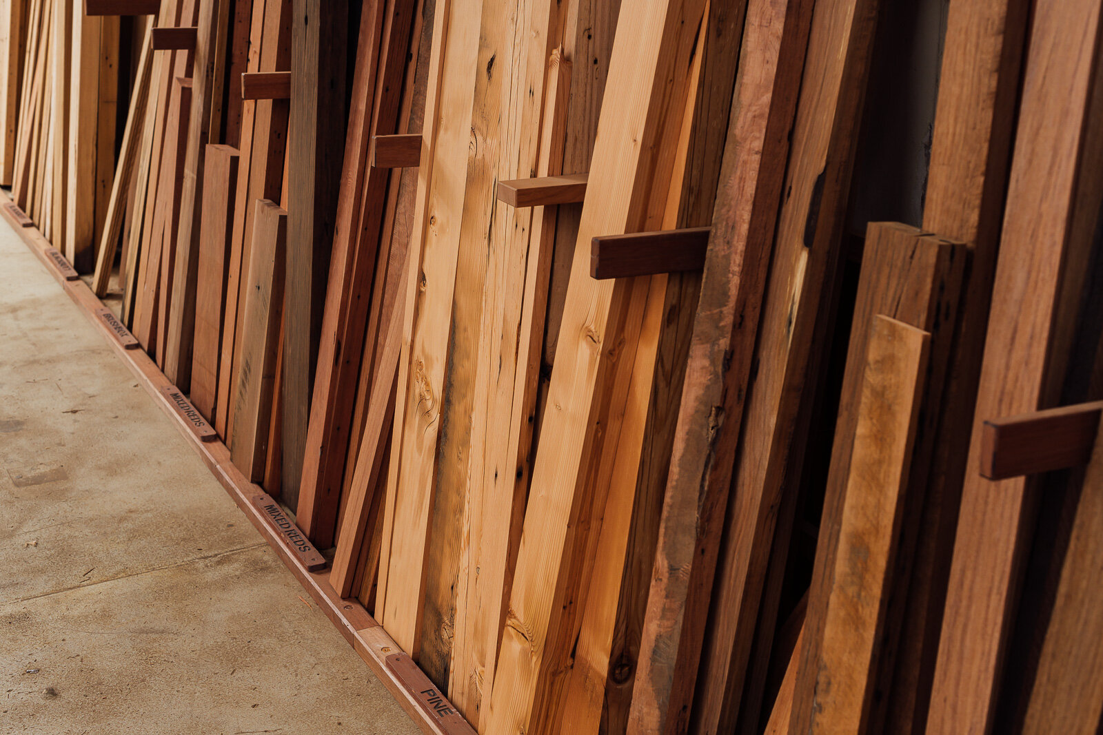 Different varieties and sizes of one-off timber slabs stored in a warehouse