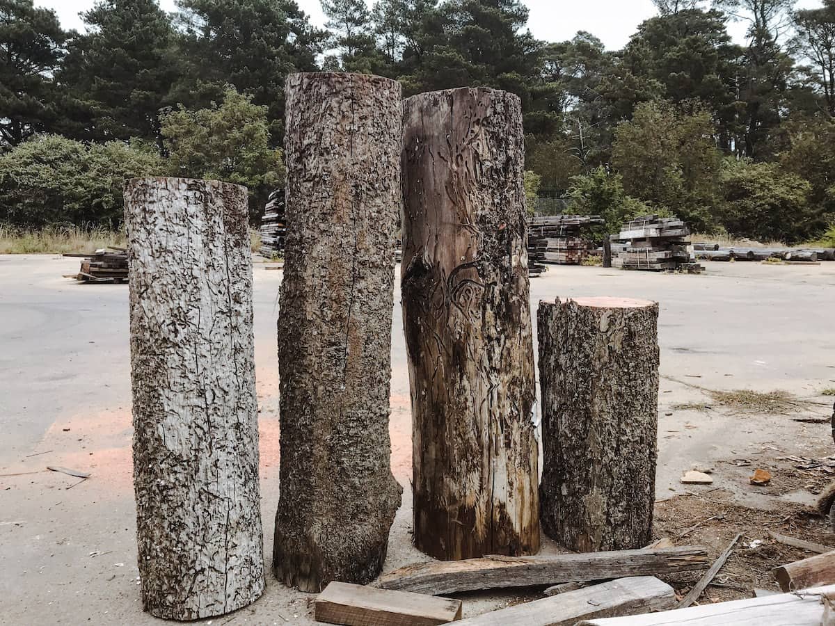 Four long recycled timber posts with art carvings