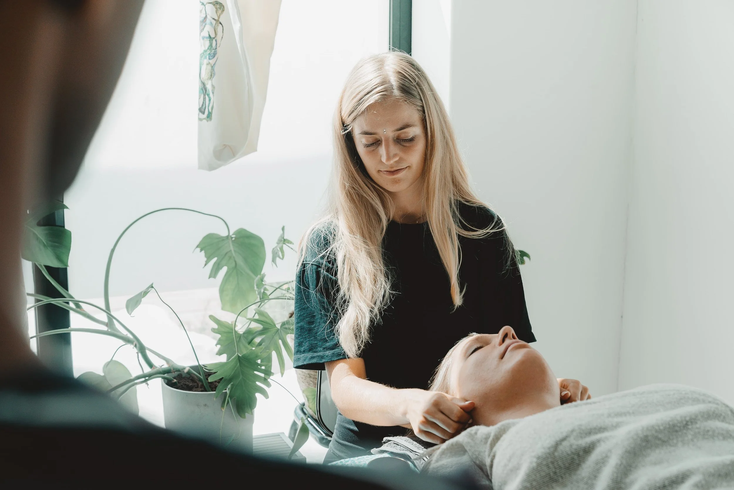 a woman looking down while touching the head of another woman while others are watching