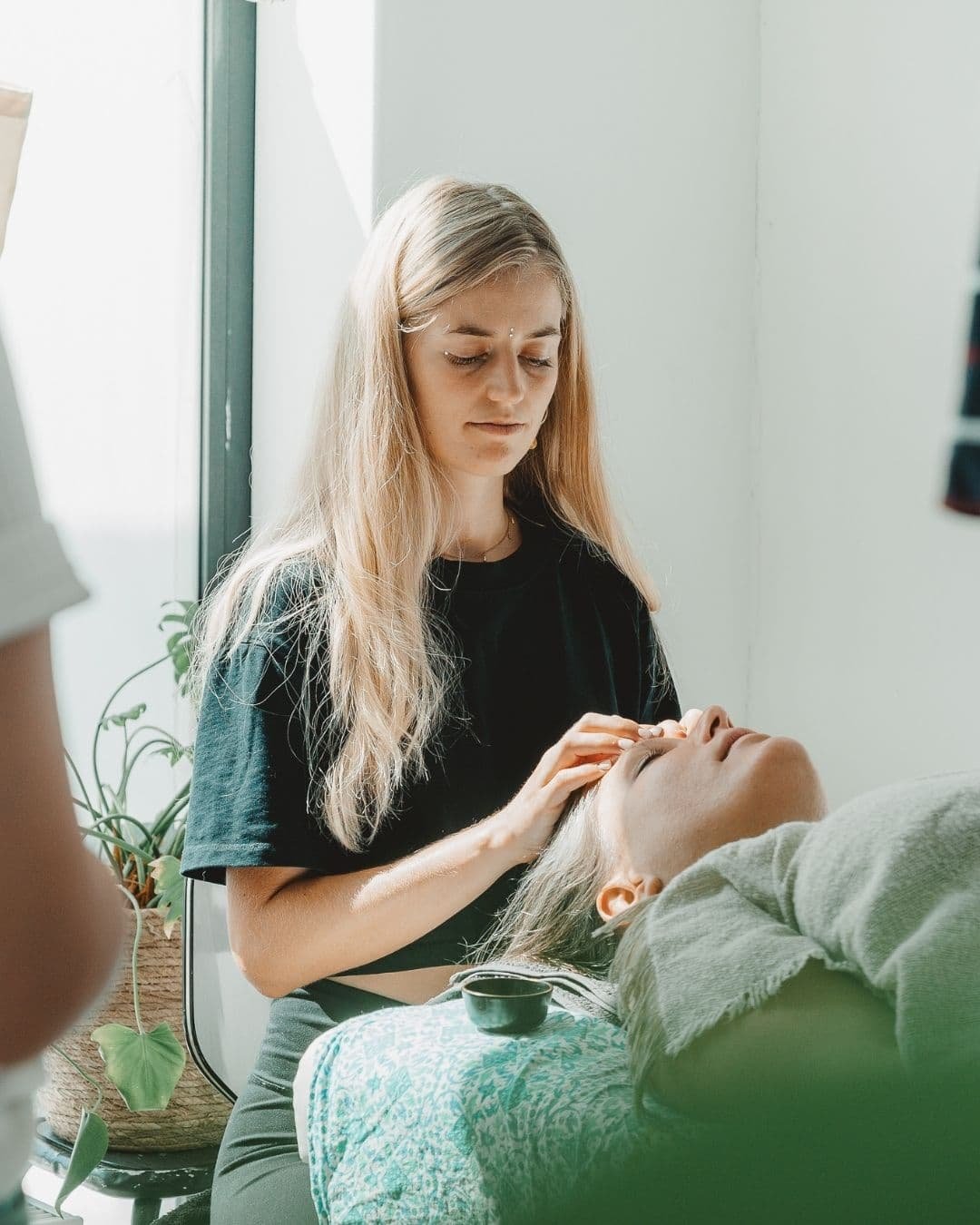 a girl massaging another woman on her head
