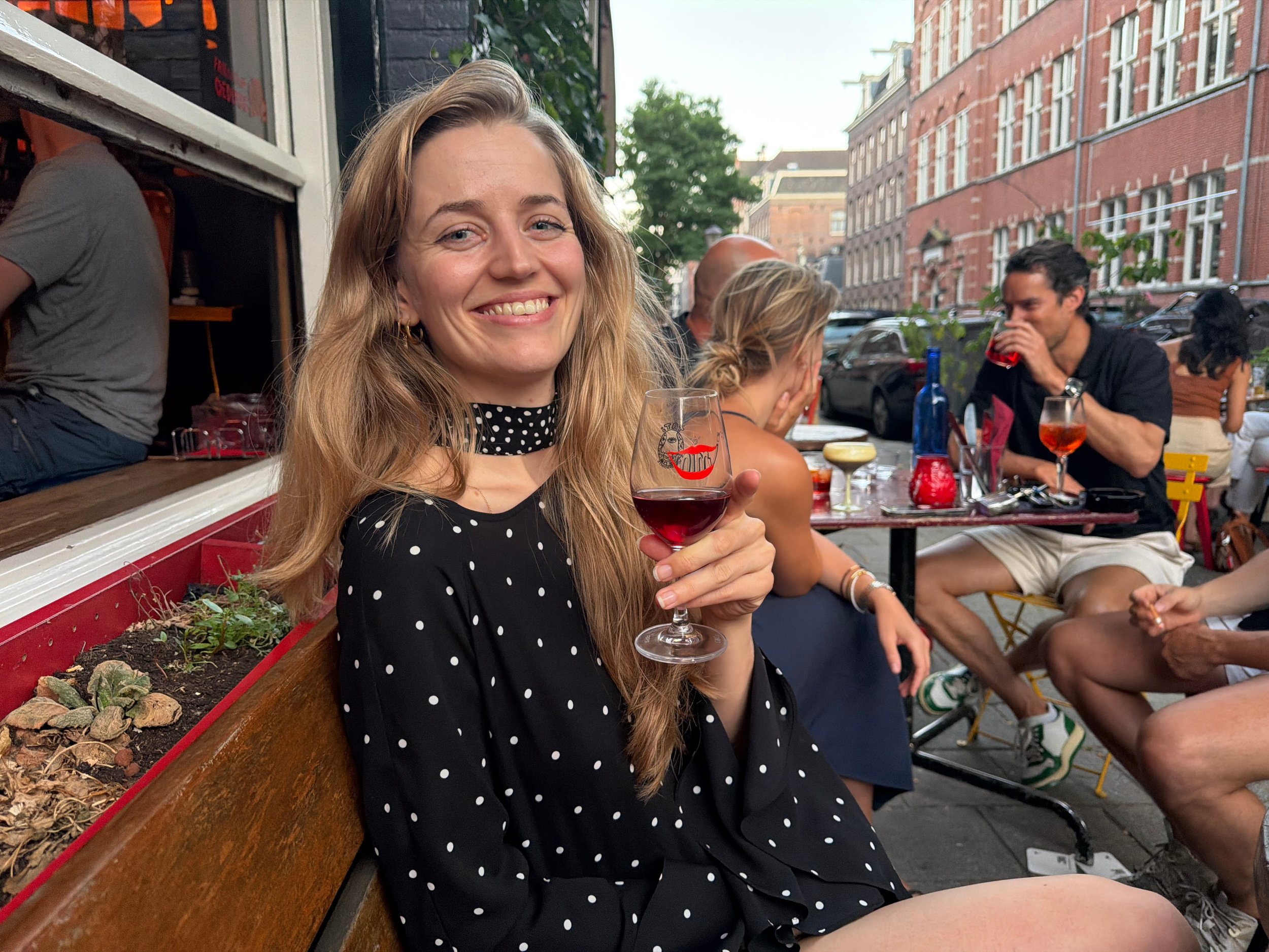 woman sitting outside at a bar with a glass of wine