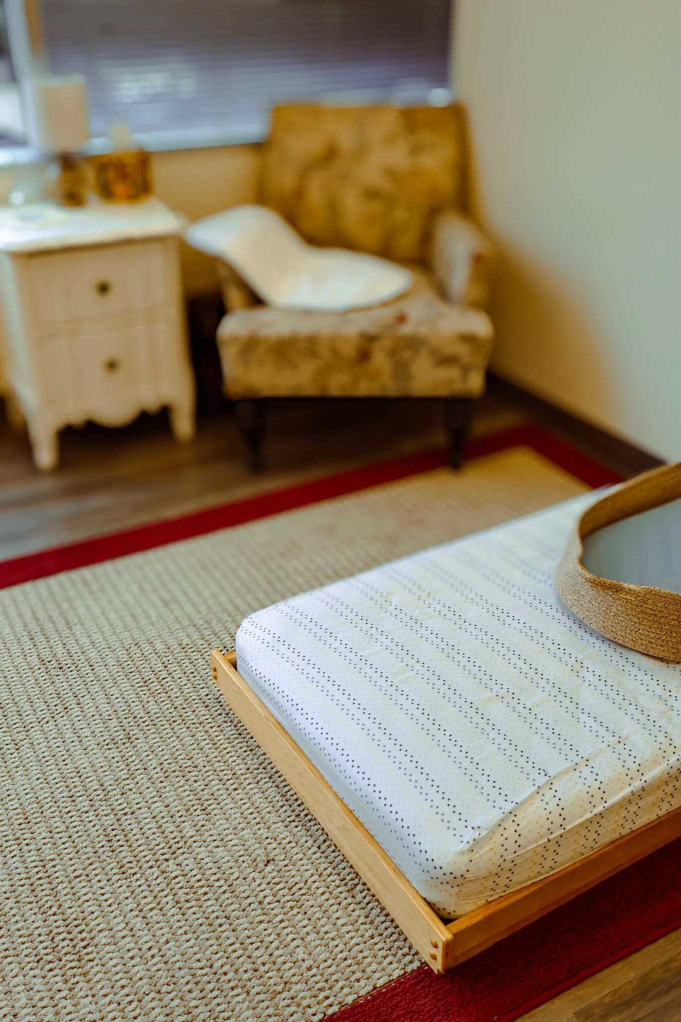 In this sleepy corner of the Nido, Birth to 18 months, even the smallest details support an infant's development. You can see a adult chair for orienting a child to their sleep space, a topponcino (a small, thin, quilted mattress used in Montessori e
