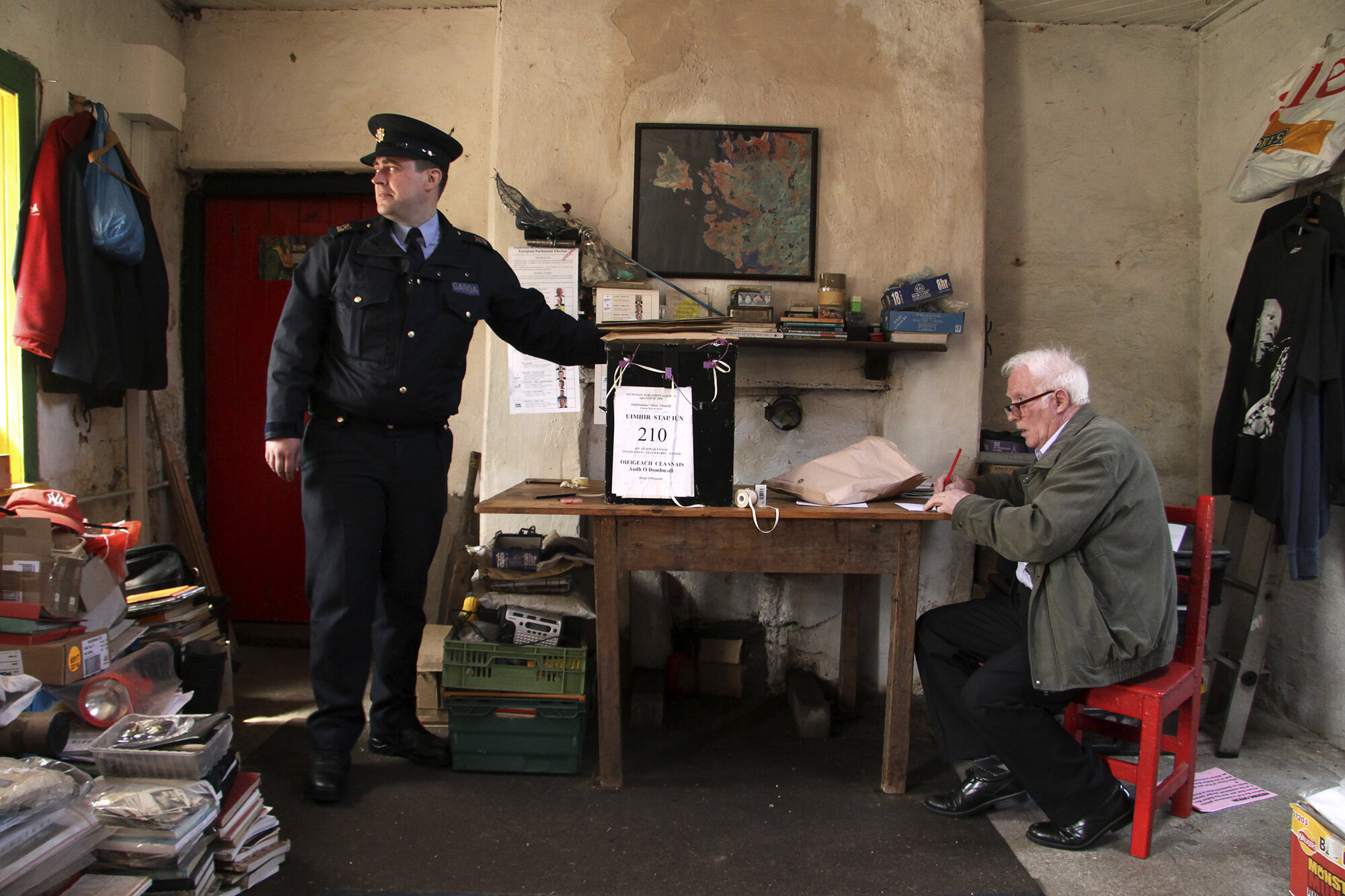 Gardai Damian Mulkearns (L) stands beside the ballot box next to presiding officer Hugh O'Donnell, on the island of Inishfree ahead of European and local elections, 2009.