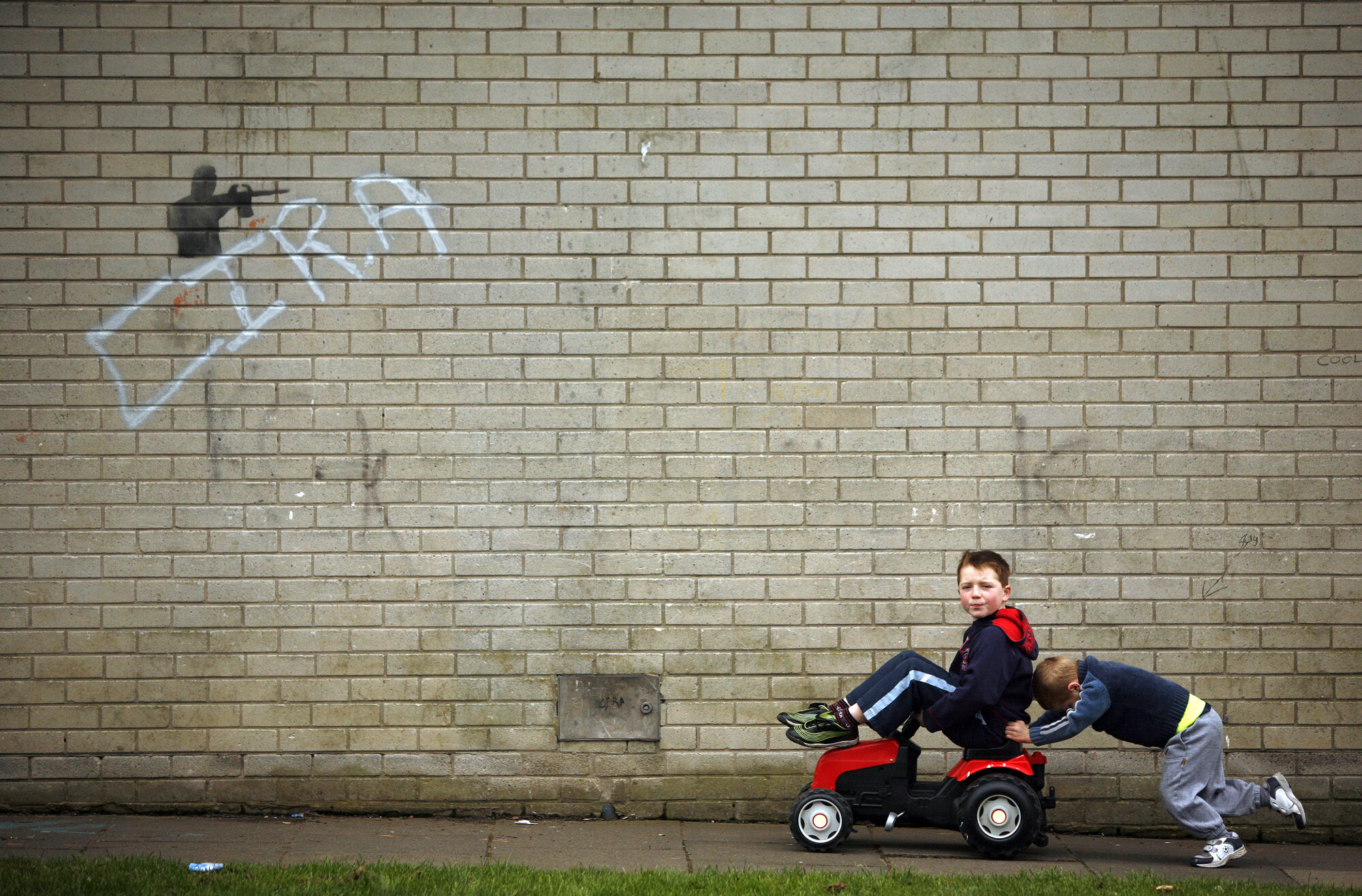 Children play under Dissident Republican graffiti in Craigavon, 2009.