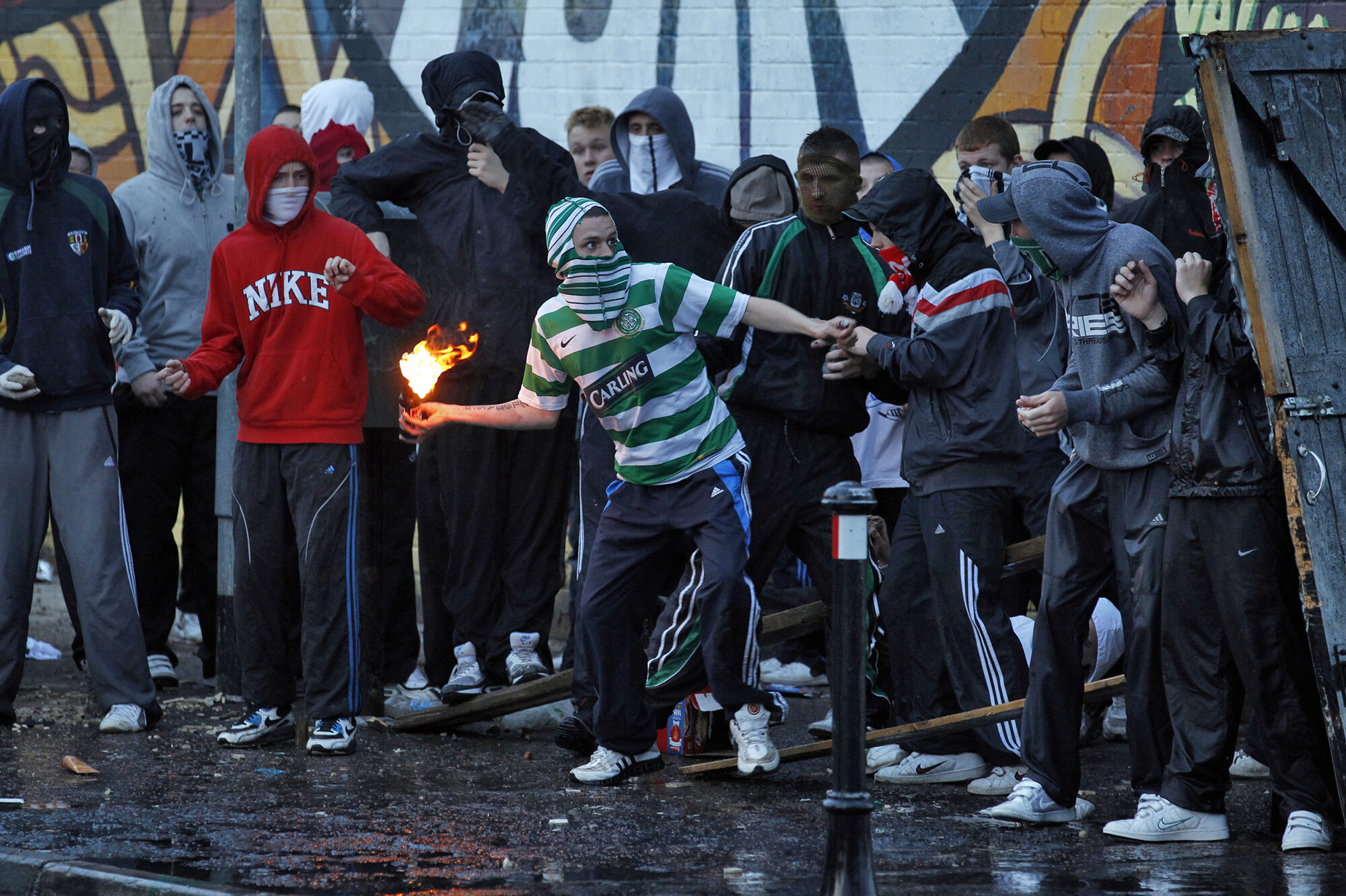 A Nationalist youth throws a petrol bomb at members of the security forces in the Ardoyne area of North Belfast after a Orange Order parade made it's way through the area, 2010.
