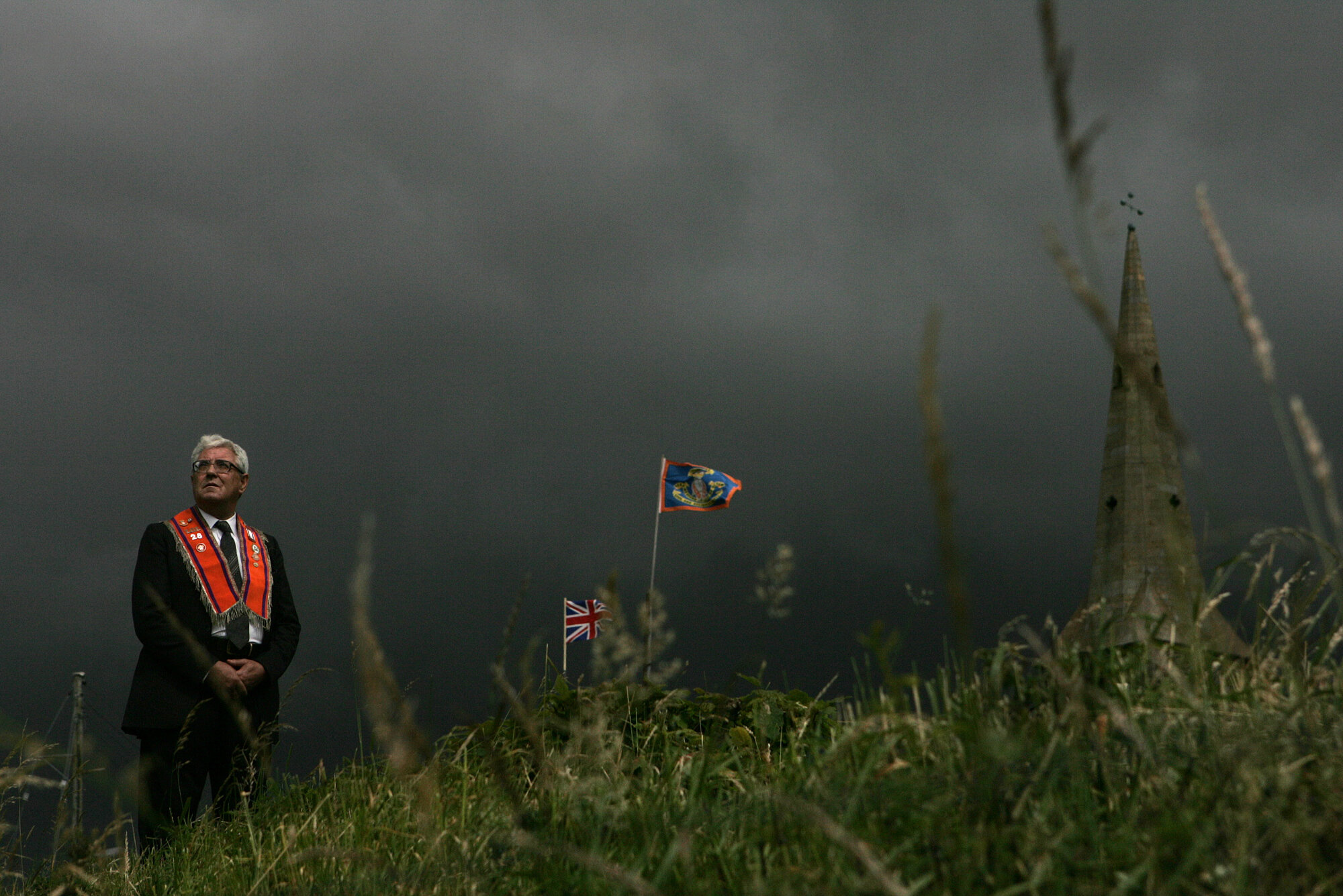 A member of the Protestant Orange Order prays on a hill beside Drumcree Parish church, Portadown, 2004.