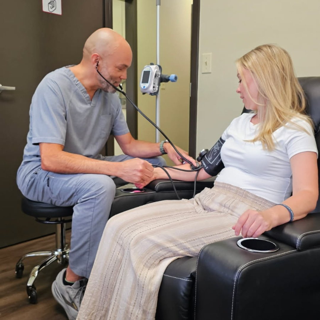 A healthcare professional taking a woman's blood pressure in a medical setting.