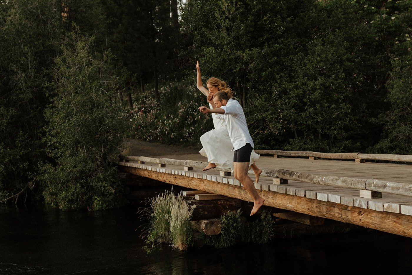 Couple jumping into the Metolius river after their wedding