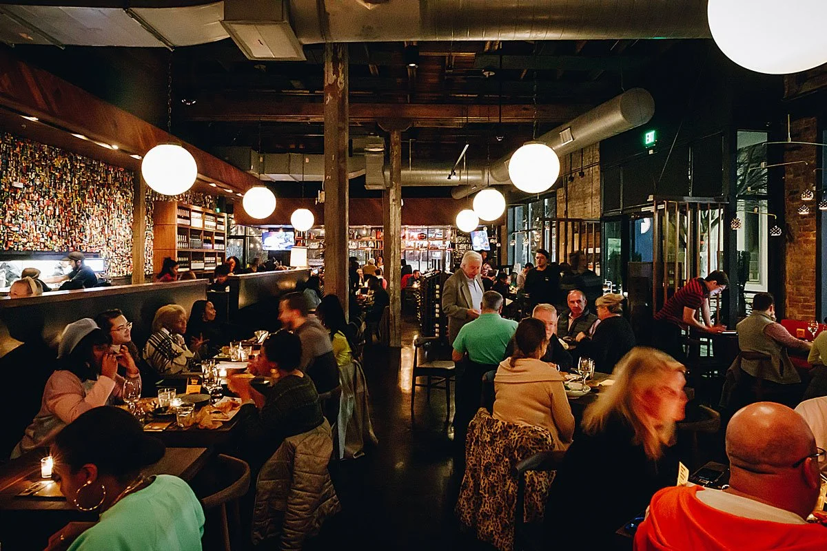 Interior of Postino WineCafé, filled with guests and servers.