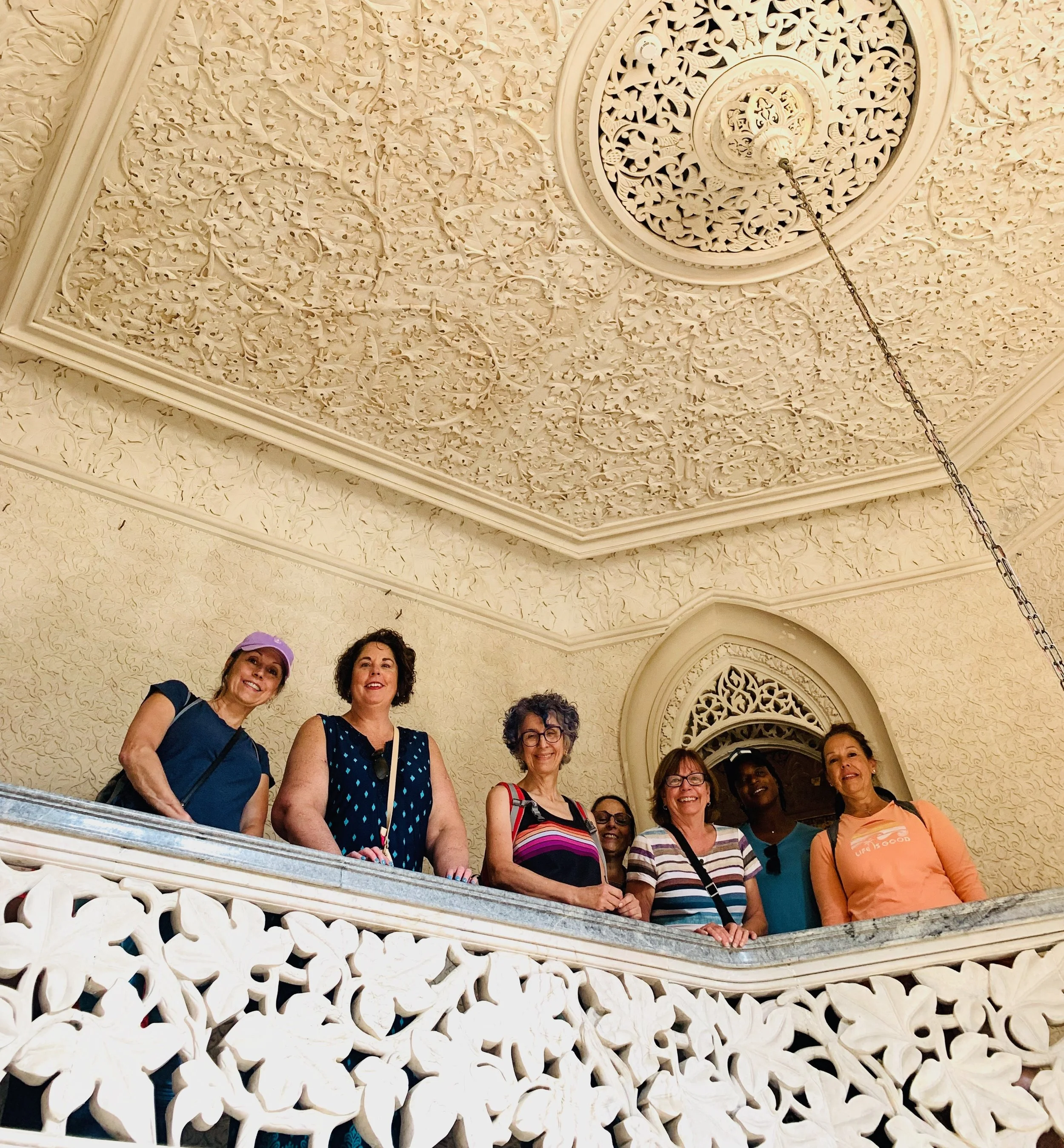 Group of women posing on balcony in Portugal on a womens trip