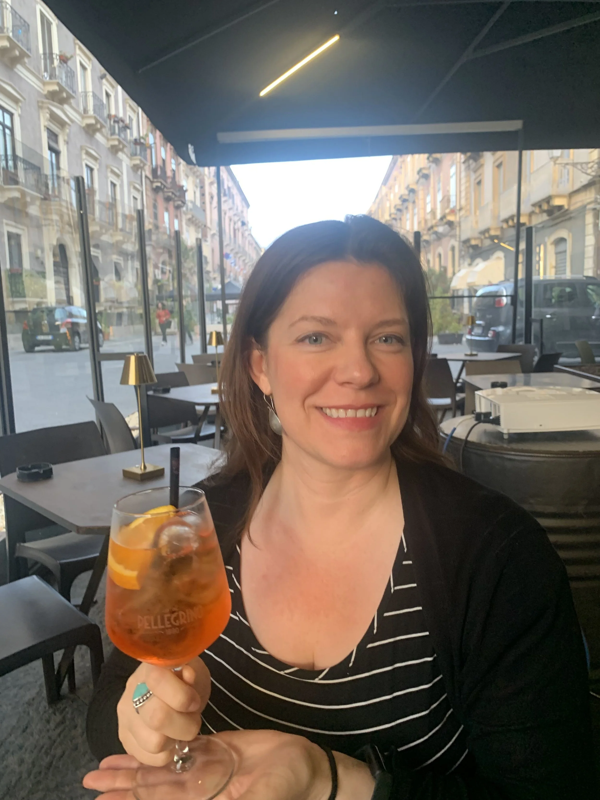 Woman traveler drinking Aperol Spritz in Sicily