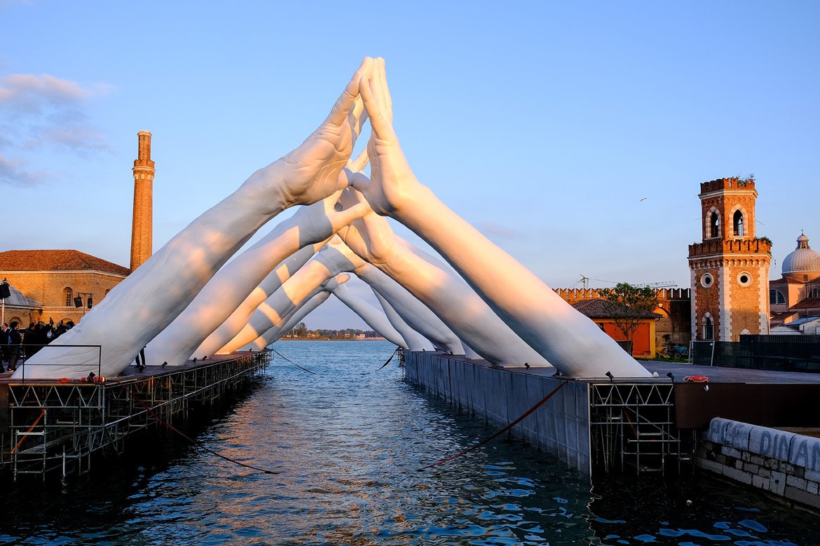 https://images.squarespace-cdn.com/content/v1/5dd5ba0cbccc005166d0887c/1683484821800-3UI9EN1RYCEBALQ8G5A1/Building-Bridges-Venice-Italy-01-Installations-Lorenzo-Quinn.jpg