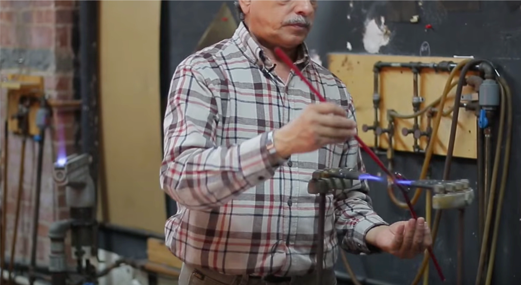  Neon glass fabricator using a torch to bend the glass tube. Video Still: The Past, Present and Future of Neon in New York w/ Let There Be Neon (15:03-15:14)         