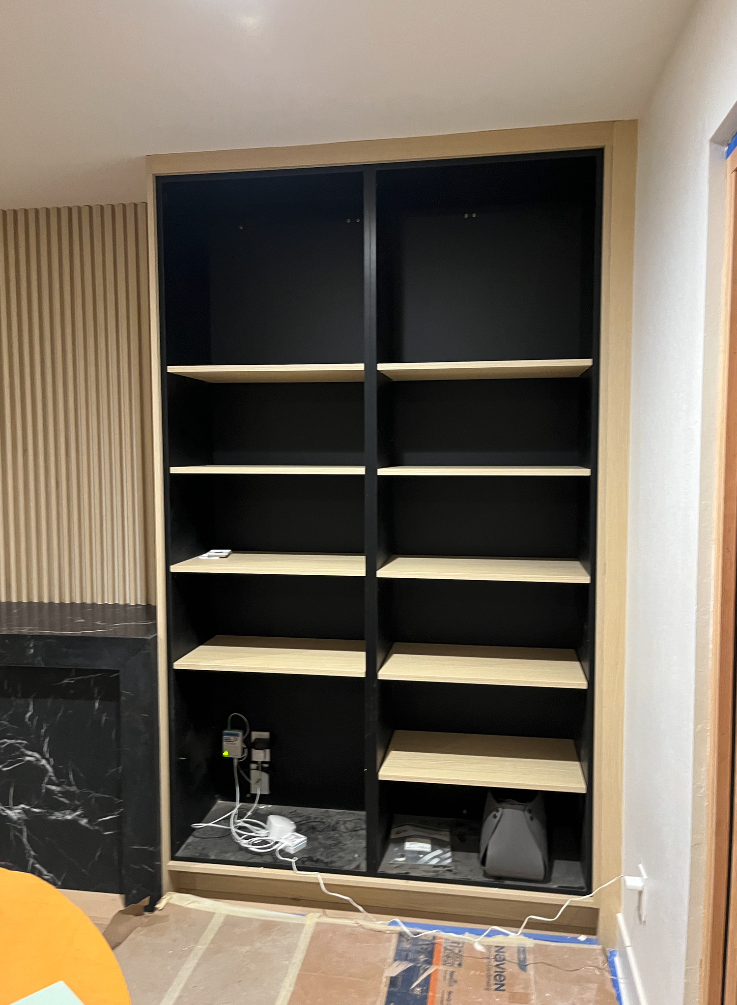 Slat wall over fireplace. Built-in bookcase & display cabinet.
