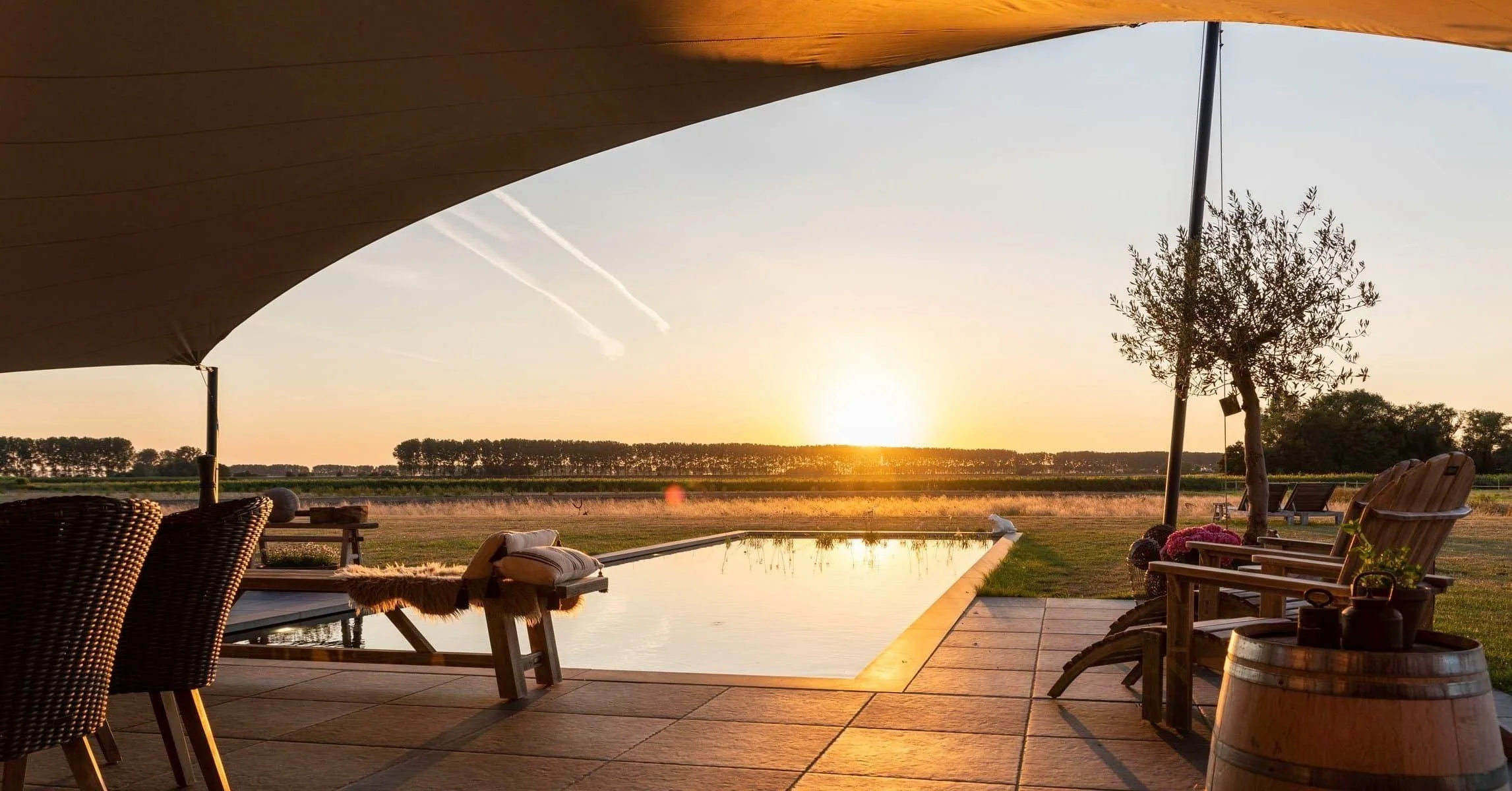 Uitzicht over de zwembad van Het Verborgen Geluk een adults only boutique B&B, verborgen in de polders van Zeeuws Vlaanderen