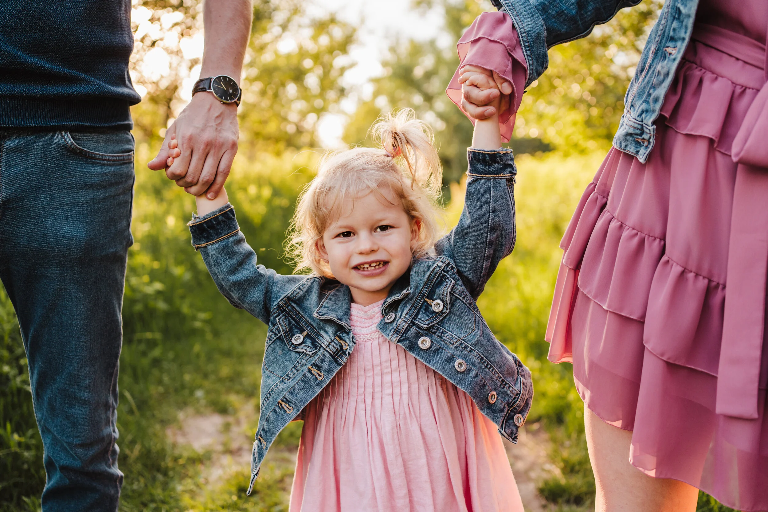 dziewczynka trzyma rodziców za ręce
