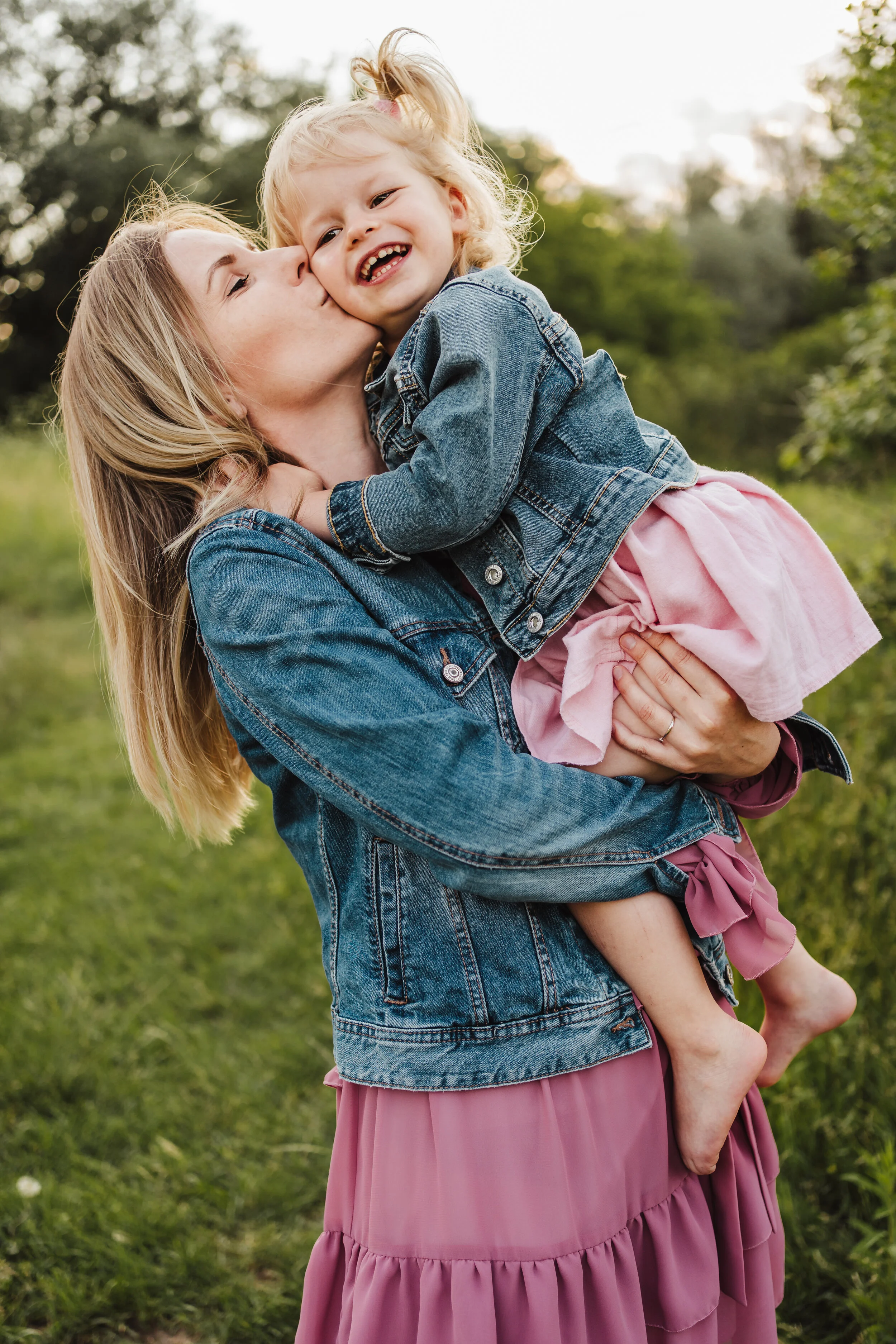 mama całuje dziecko w plenerze