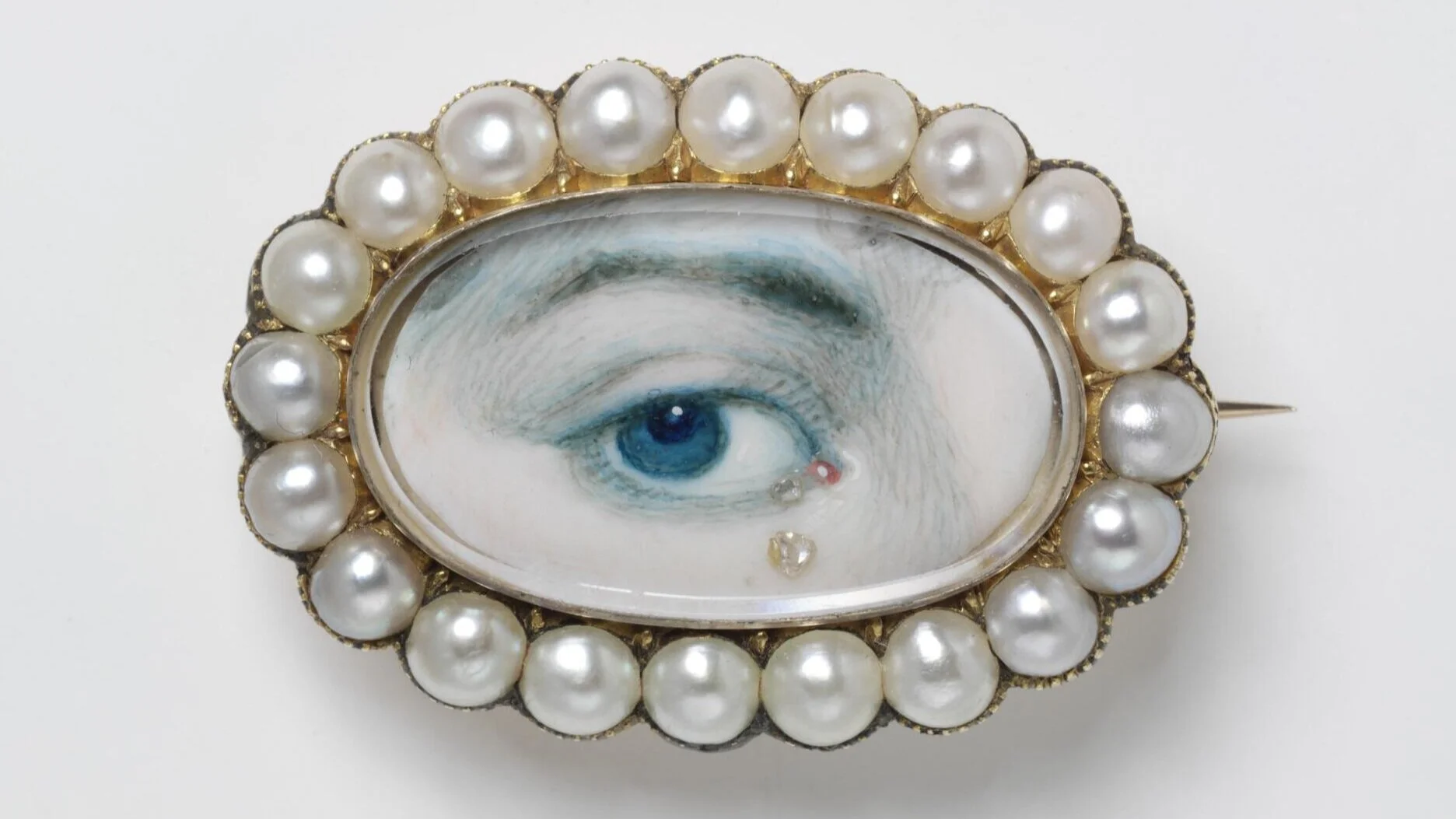 What is a Lover’s Eye?  Today we may send a selfie to our partner, but between the 1780s and 1820s, a Lover’s Eye jewel was a secret way in which romantic relationships communicated. A painted miniature portrait of a person’s eye, these tiny pieces were only centimeters in size and were exchanged between pining lovers. Due to their small stature, Lover’s Eye jewellery could be both secretly or overtly worn, with the former for unknown courtships and the latter for public displays of affection.&nbsp;  The painted portrait was often crowned with gems and displayed in ovals, crescent moons or floral-like clusters to emphasise their inherent romantic nature. In many ways, these jewels were a literal jeweller’s version of a synecdoche, with the eye communicating the whole being’s intimate love and devotion. This one eye is the lustful watching gaze of their beloved, a “look” that can only be understood between romantic partners.&nbsp;  In fact, eagle-eyed (pardon the pun) viewers may have noticed that this particular style of jewellery was actually shown in Bridgerton! Marina Thompson, the distant cousin of the Featherington family, is shown wearing a Lover’s Eye pendant in her opening scenes, an instant sign that she has promised her heart to another suitor.&nbsp;