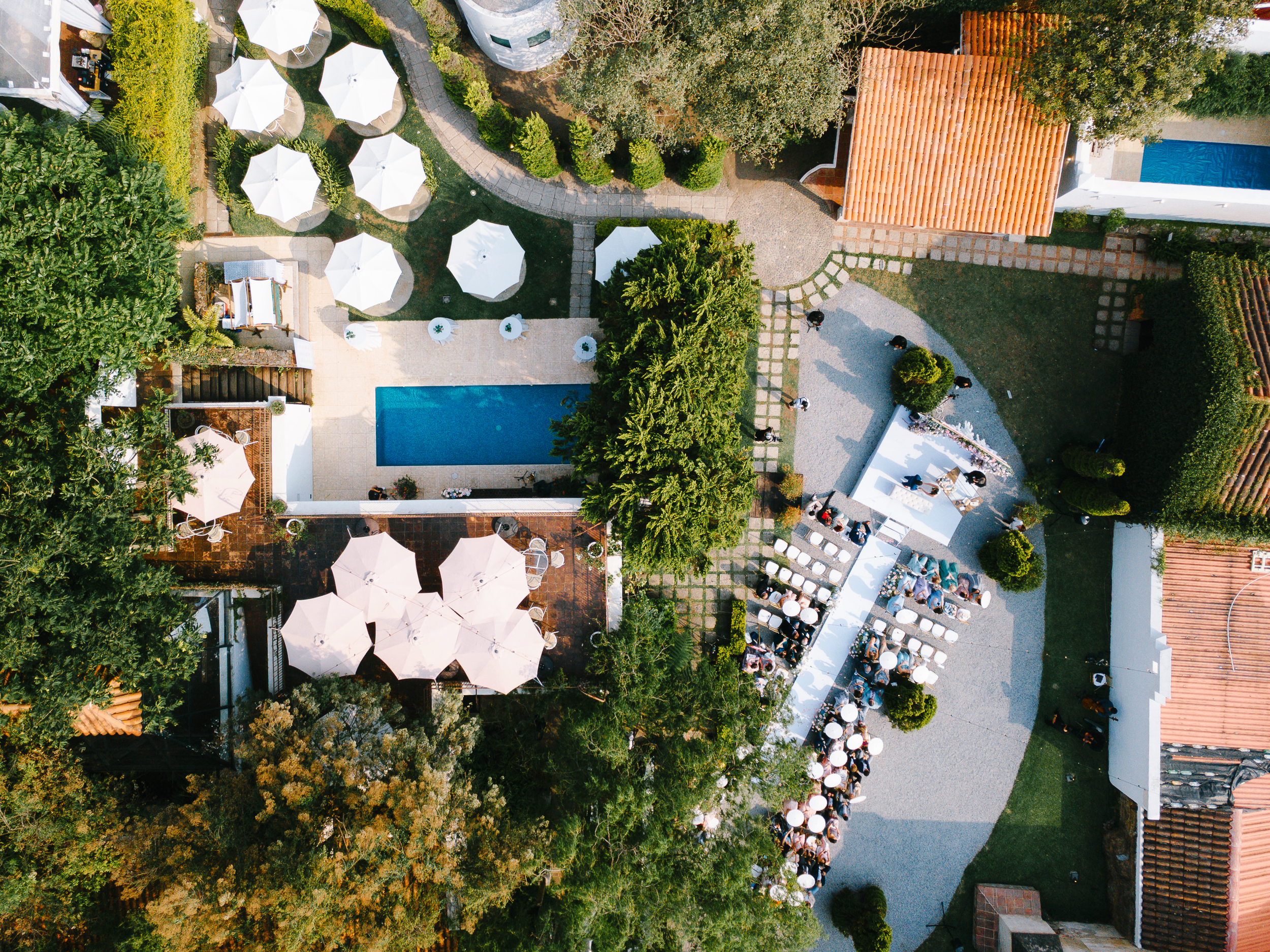 Wedding ceremony setup in Conceptio's private garden with flowers and aerial view of the pool and colonial garden
