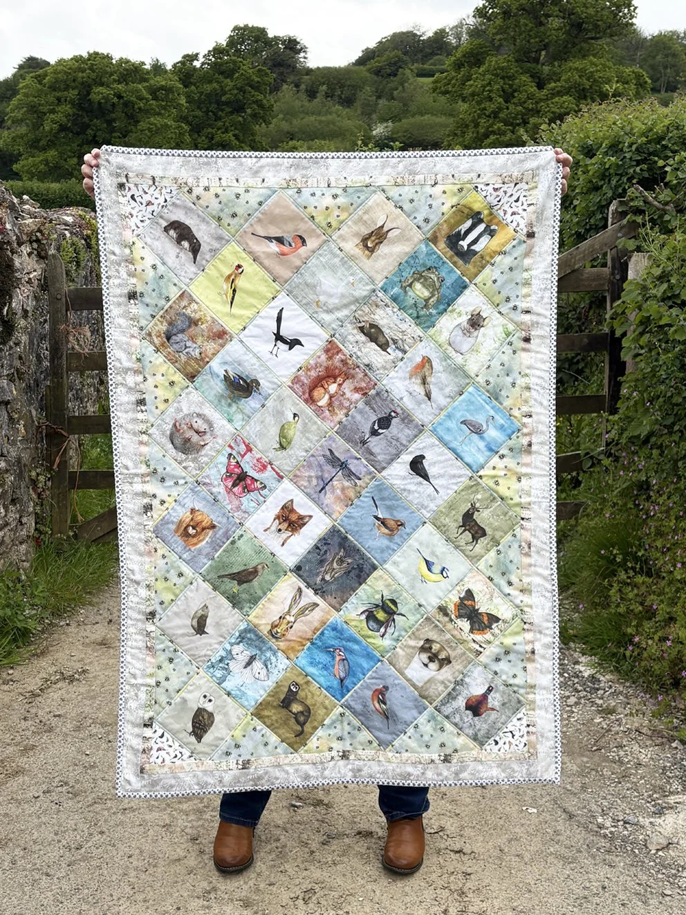 WILDLIFE QUILT INFRONT OF A FARM GATE.jpeg