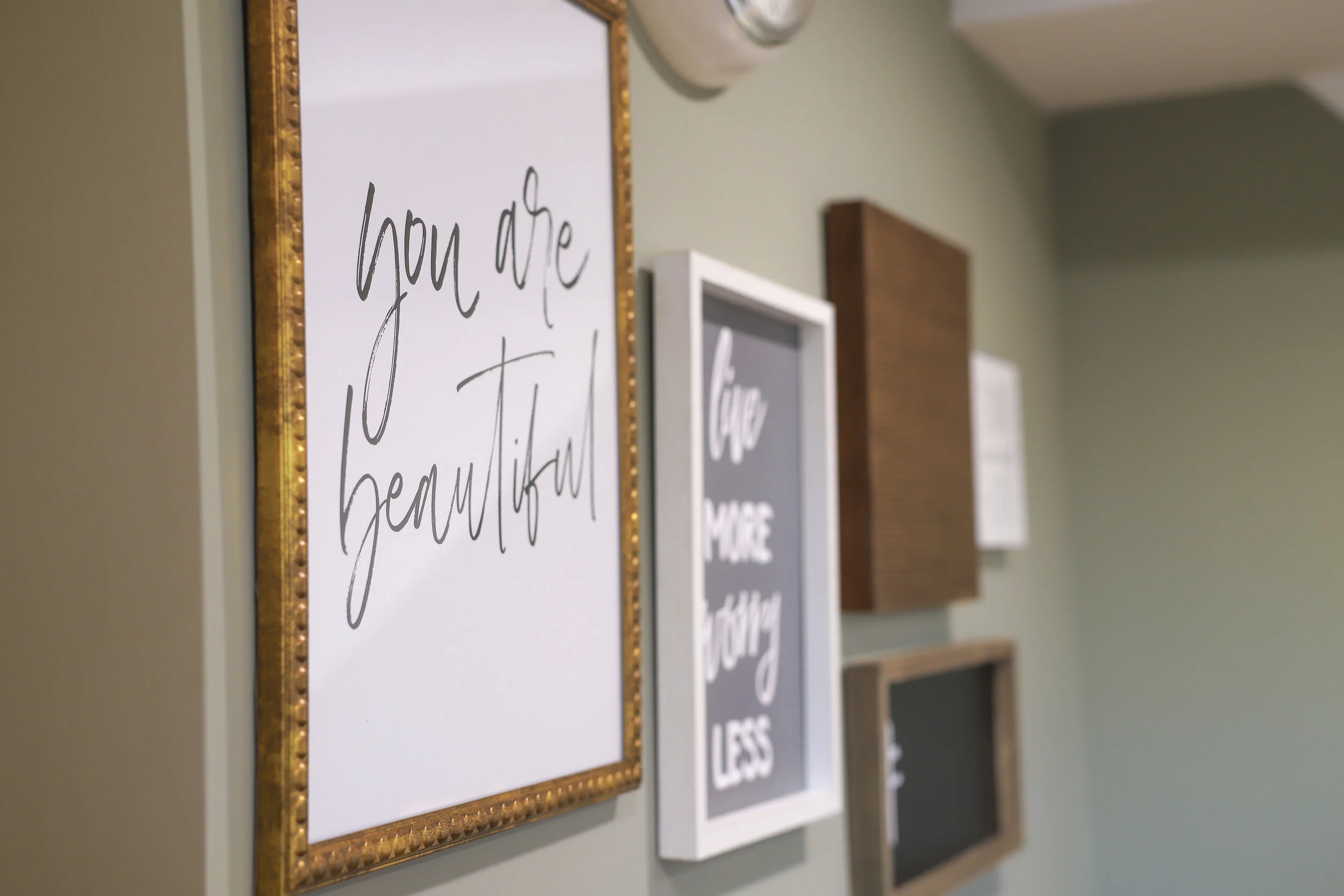 Decorative wall frames with motivational quotes, including "You are beautiful."