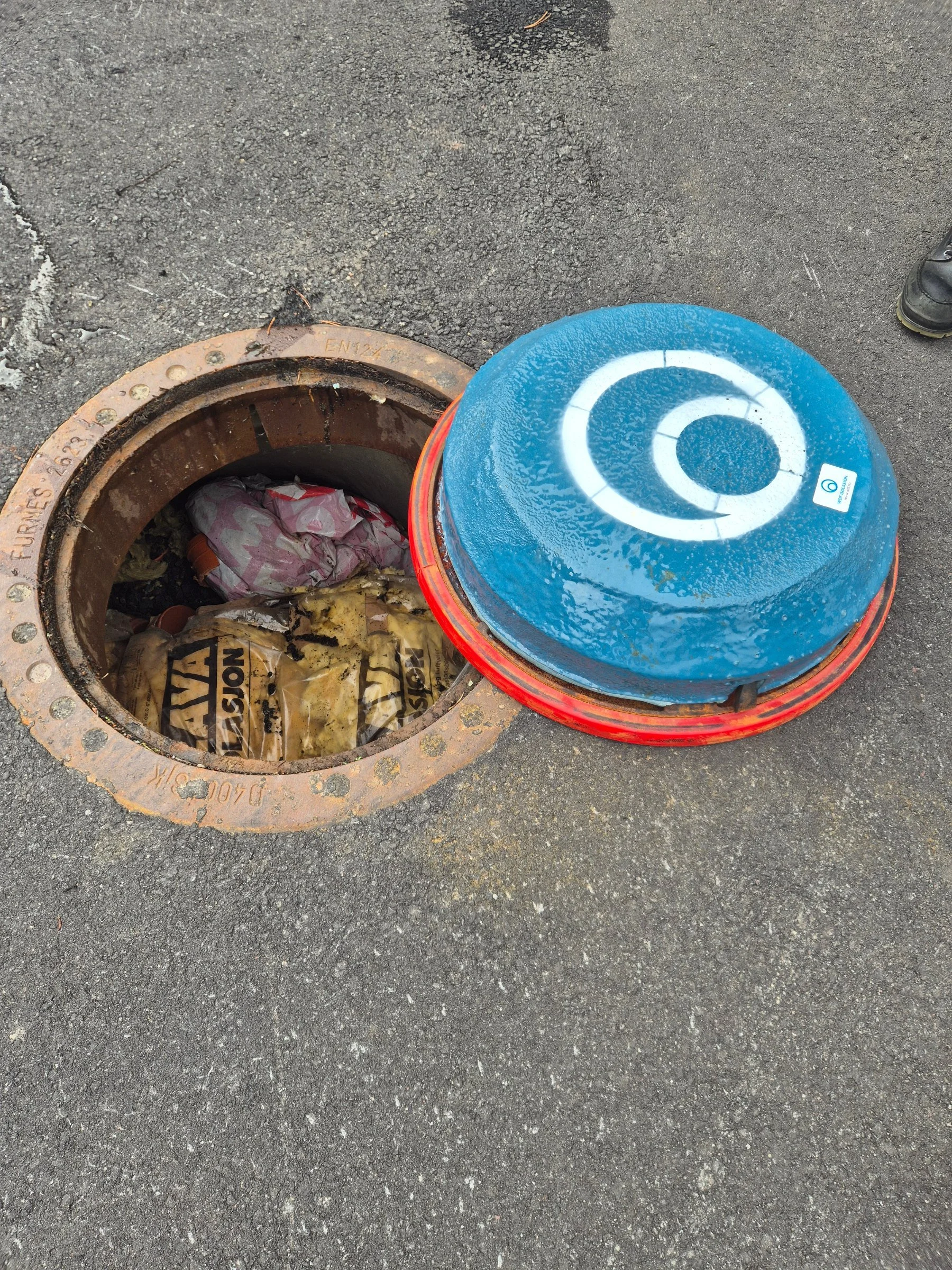 Blue Turtle isolasjonslokk ved siden av åpen kum